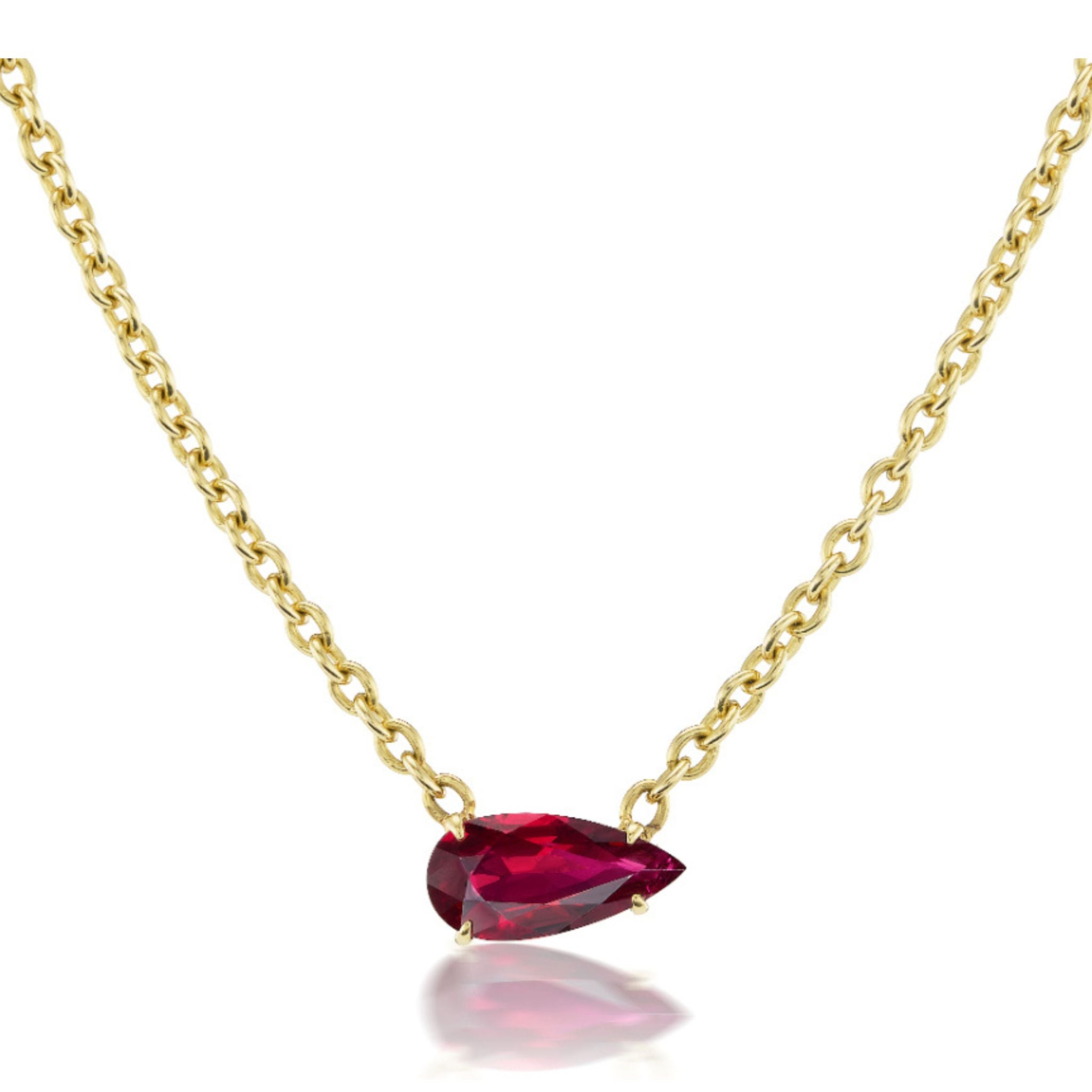 Introducing the East-West Pear Ruby Solitaire Pendant in Yellow Gold—a stunning gold chain necklace showcasing a pear-shaped ruby solitaire, elegantly set in 18K yellow gold.