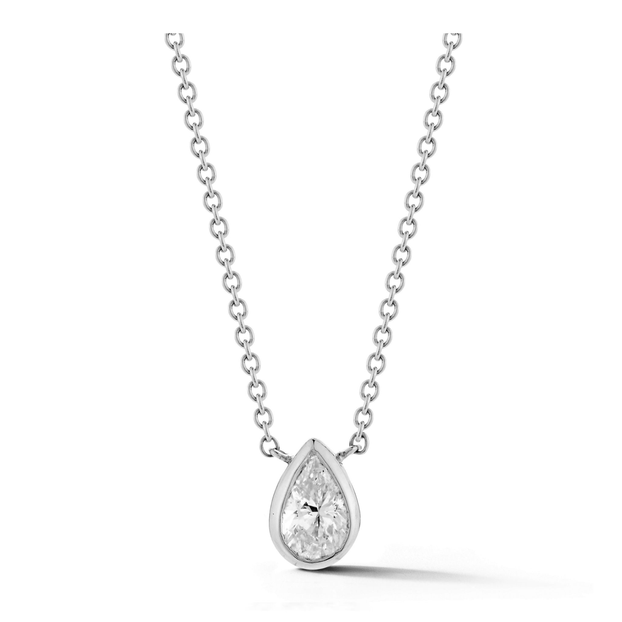 A bezel set pear diamond solitaire pendant in white gold, featuring a delicate chain and a teardrop-shaped diamond centerpiece, displayed against a white background.