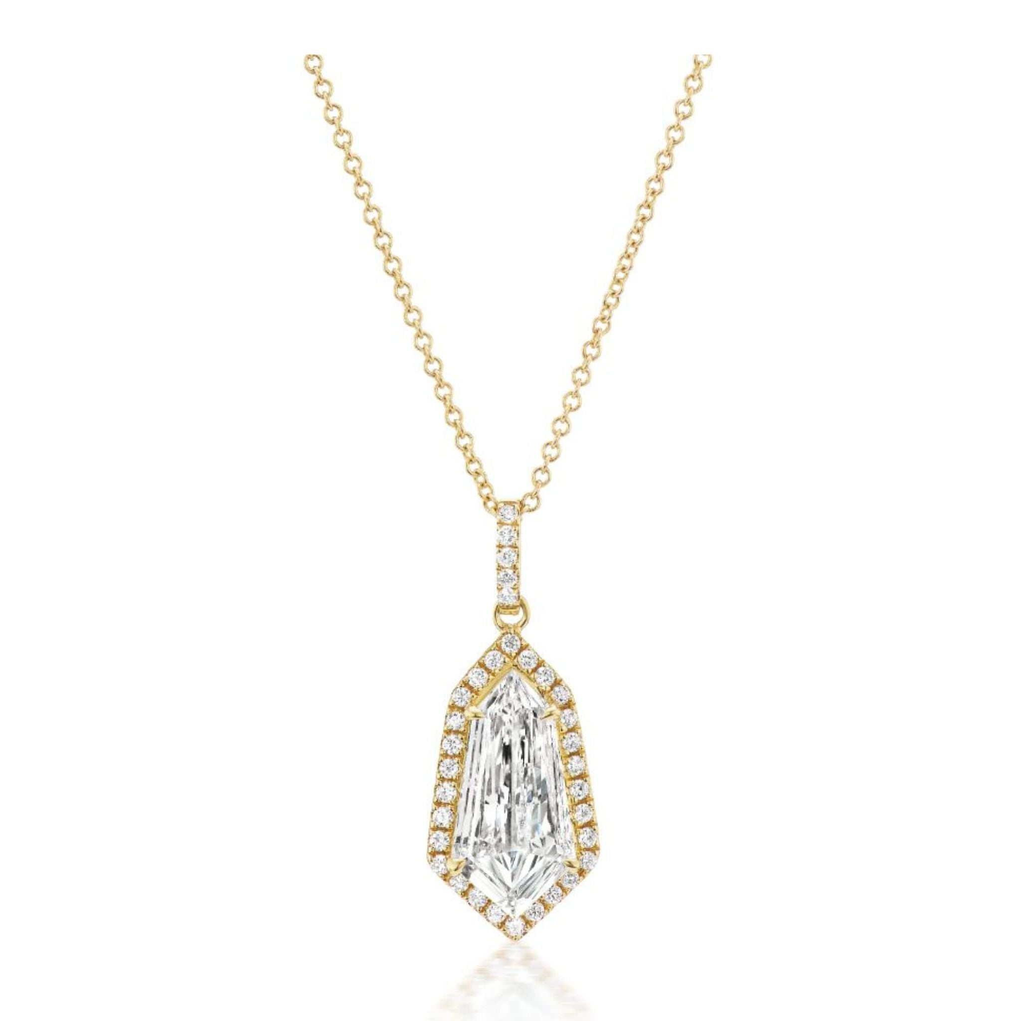 Shield Cut Diamond Pavé Pendant in Yellow Gold displayed on a white background, showcasing a solitaire shield-cut diamond at the center, surrounded by pavé-set smaller diamonds and additional diamond accents on the bail.