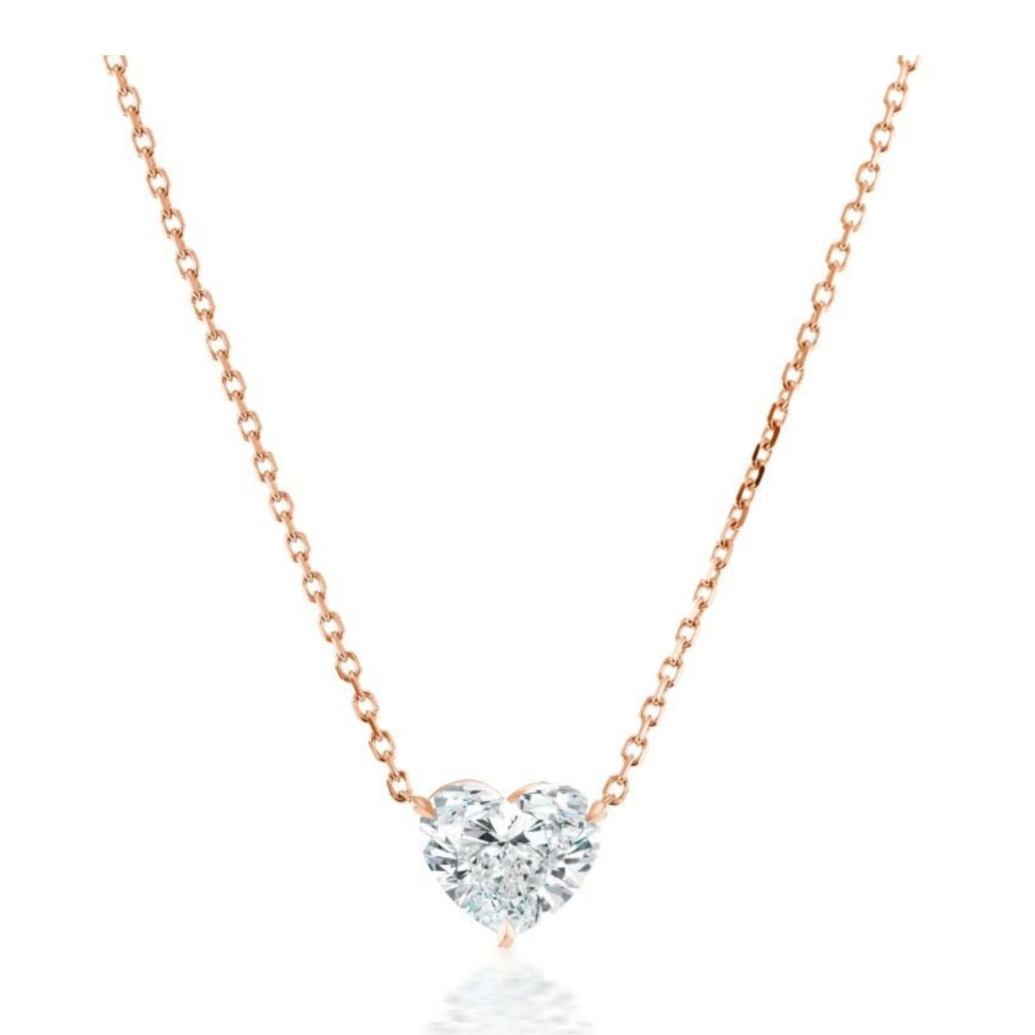 The Heart Diamond Solitaire Pendant in Rose Gold showcases a single heart-shaped diamond suspended on a delicate 18K rose gold chain, elegantly displayed against a white background.