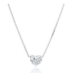 The Heart-Shaped Diamond Solitaire Pendant is showcased on a white background, featuring a delicate silver chain and a center heart-shaped diamond of F color and SI2 clarity.