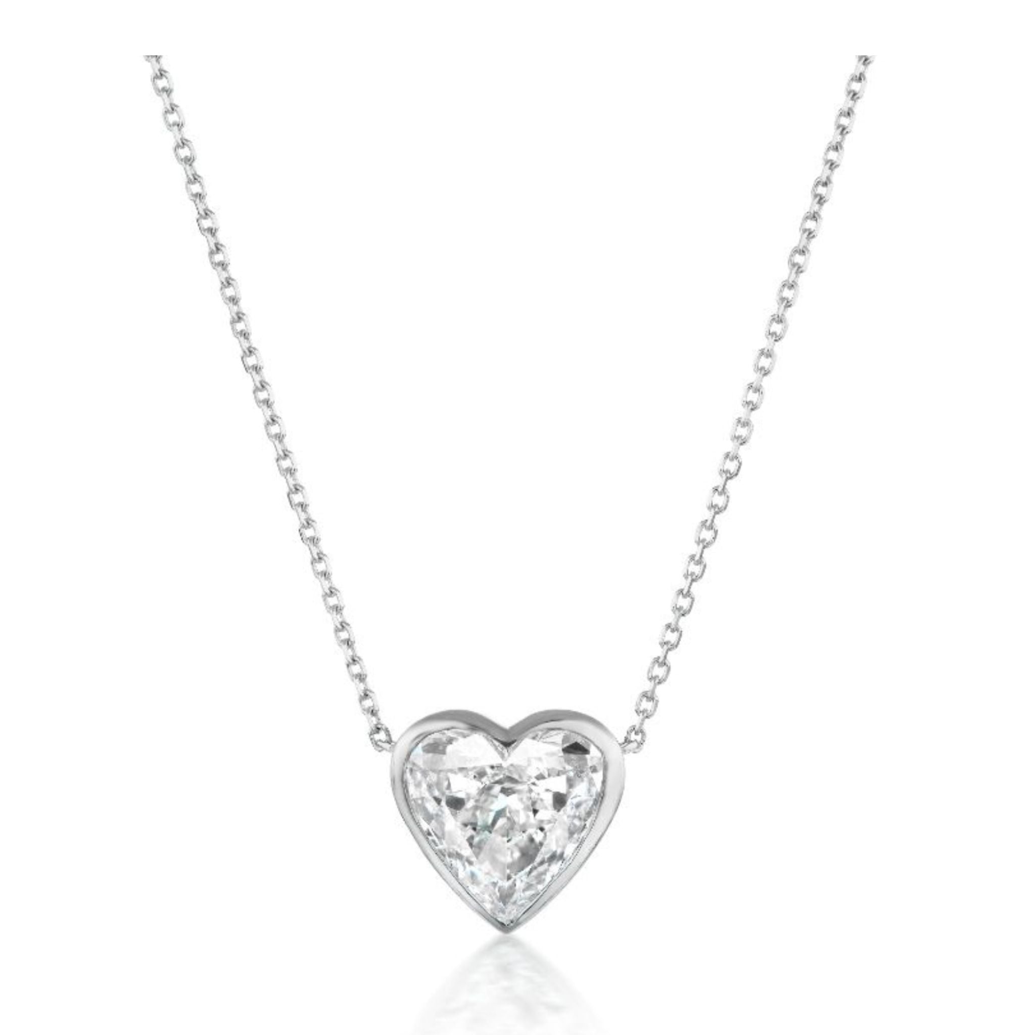 Introducing the Bezel Set Heart Diamond Solitaire Pendant in White Gold—a timeless necklace featuring a heart-shaped, clear gemstone pendant set in a classic bezel setting, beautifully suspended from an elegant silver chain.