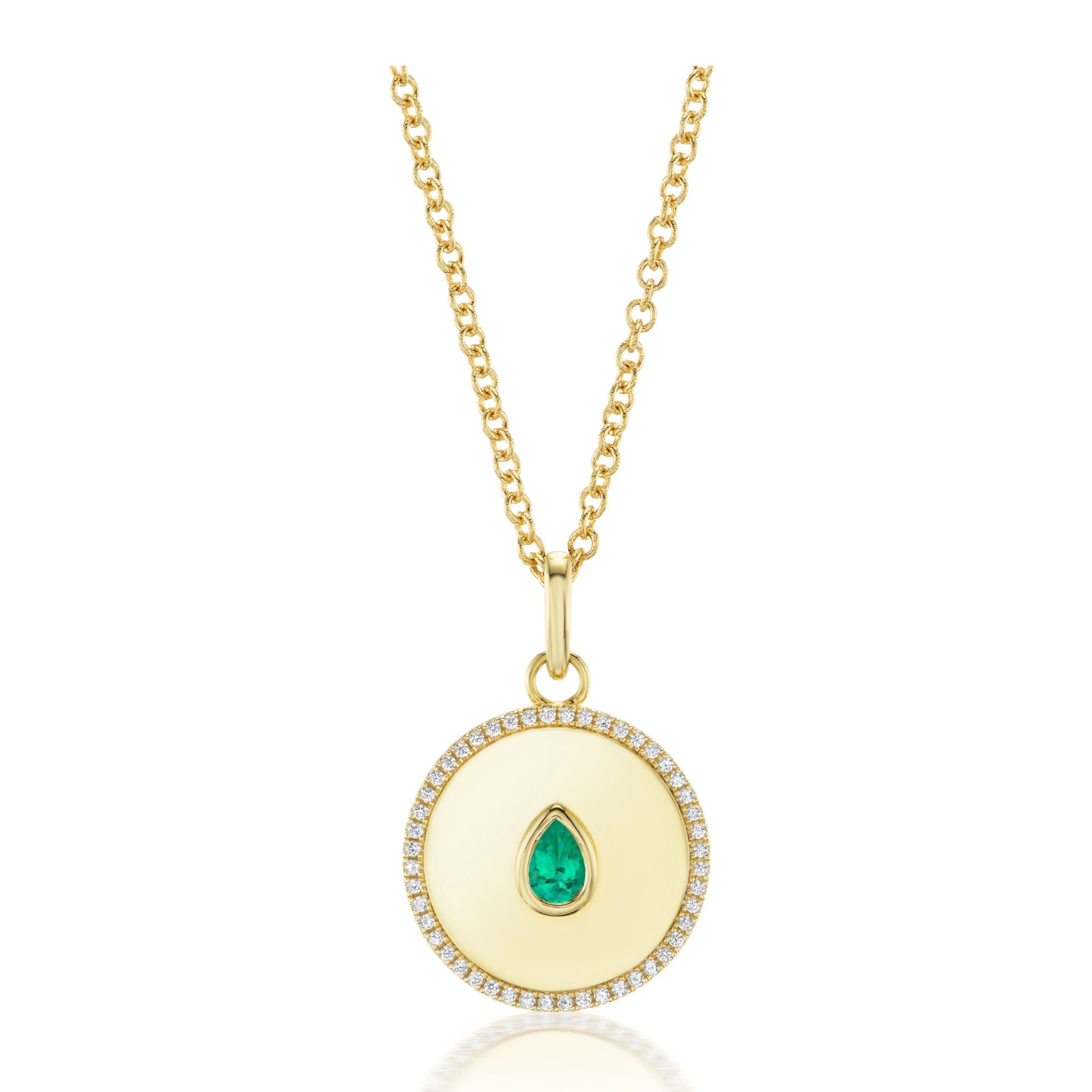 The Medallion Pendant Necklace with Bezel Set Pear Shape Emerald in Yellow Gold features an 18K yellow gold pendant with a round disc design, showcasing a pear-shaped emerald at its center and bordered by sparkling diamond pavé. This elegant pendant is suspended from a delicate gold chain.