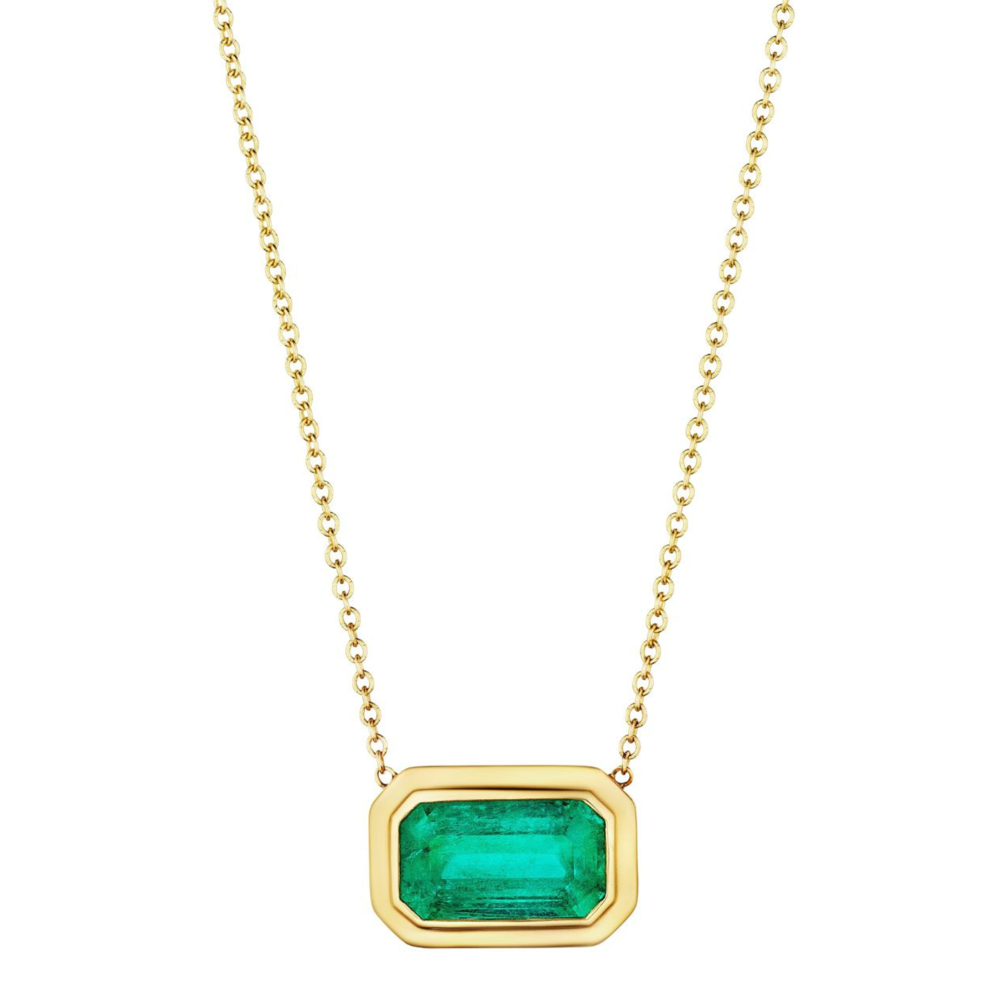 The East-West Double Bezel Set Pendant features an emerald cut Colombian emerald in a rectangular 18K yellow gold bezel on a chain necklace.