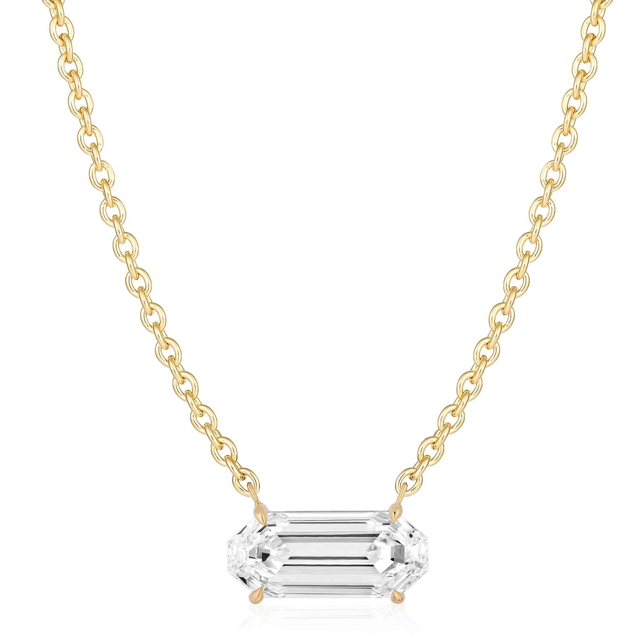 The East-West Elongated Hexagon Diamond Pendant in Yellow Gold features a horizontally set, clear hexagon diamond with beveled edges, centered on a delicate yellow gold chain and shown against a white background.