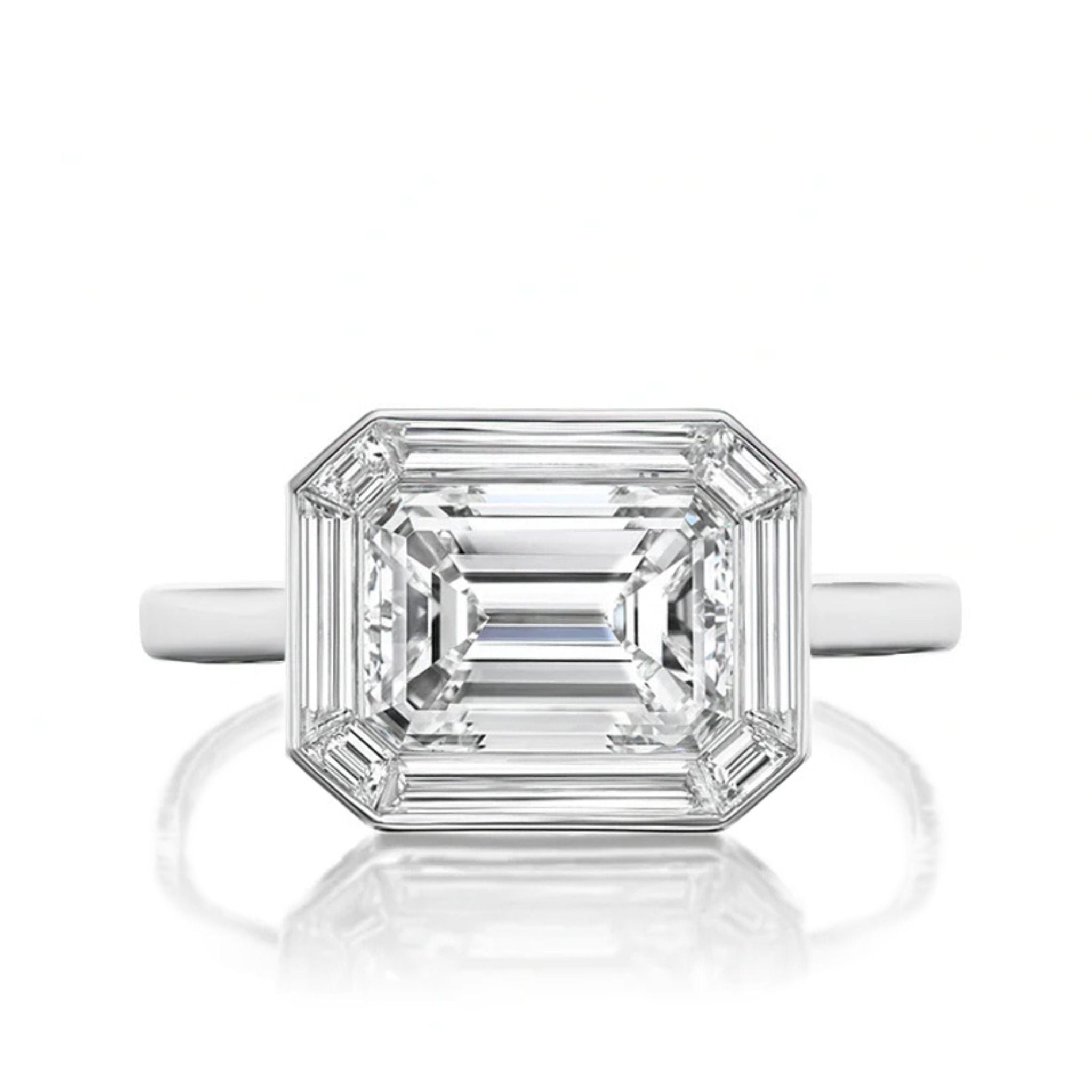 An East-West Set Mosaic Diamond Engagement Ring with an emerald-cut center diamond and baguette halo in white gold, showcased against a white background.