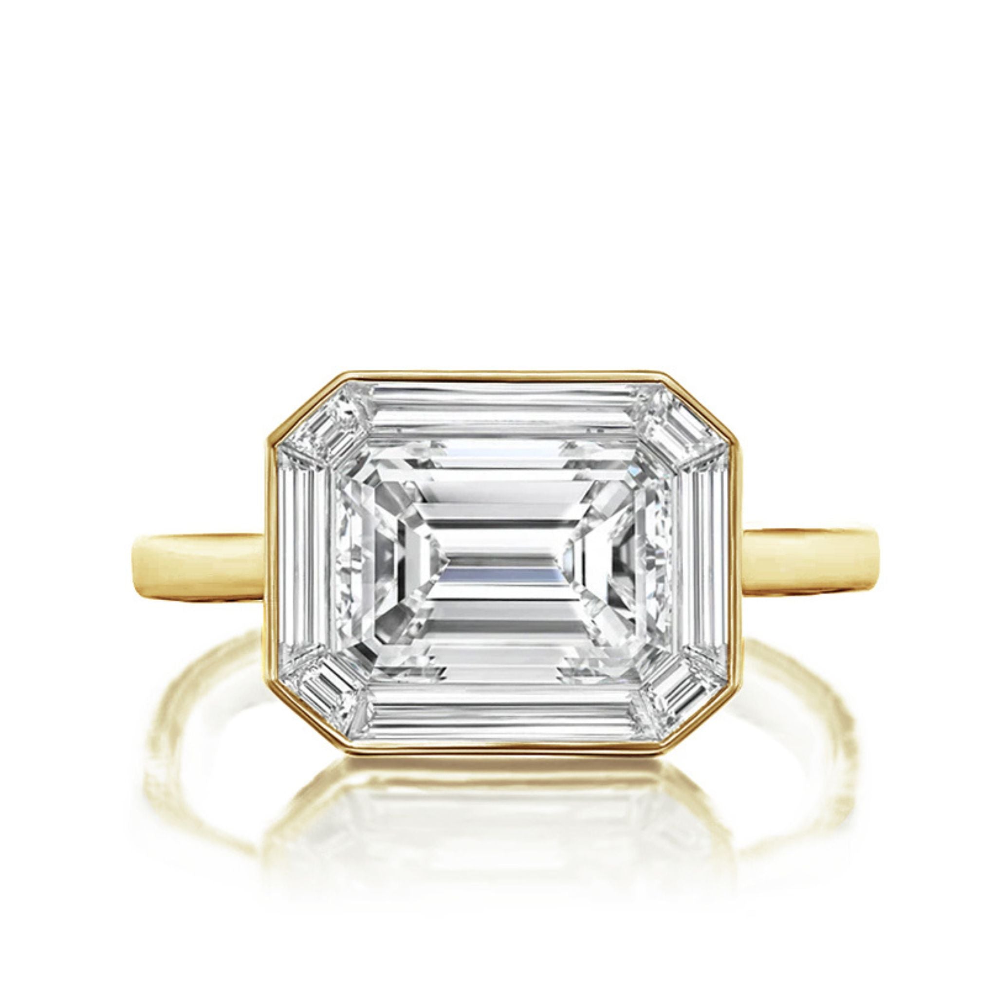 An East-West Set Mosaic Diamond Engagement Ring with an emerald-cut diamond center and baguette halo in white gold makes an elegant, modern choice for bridal rings.