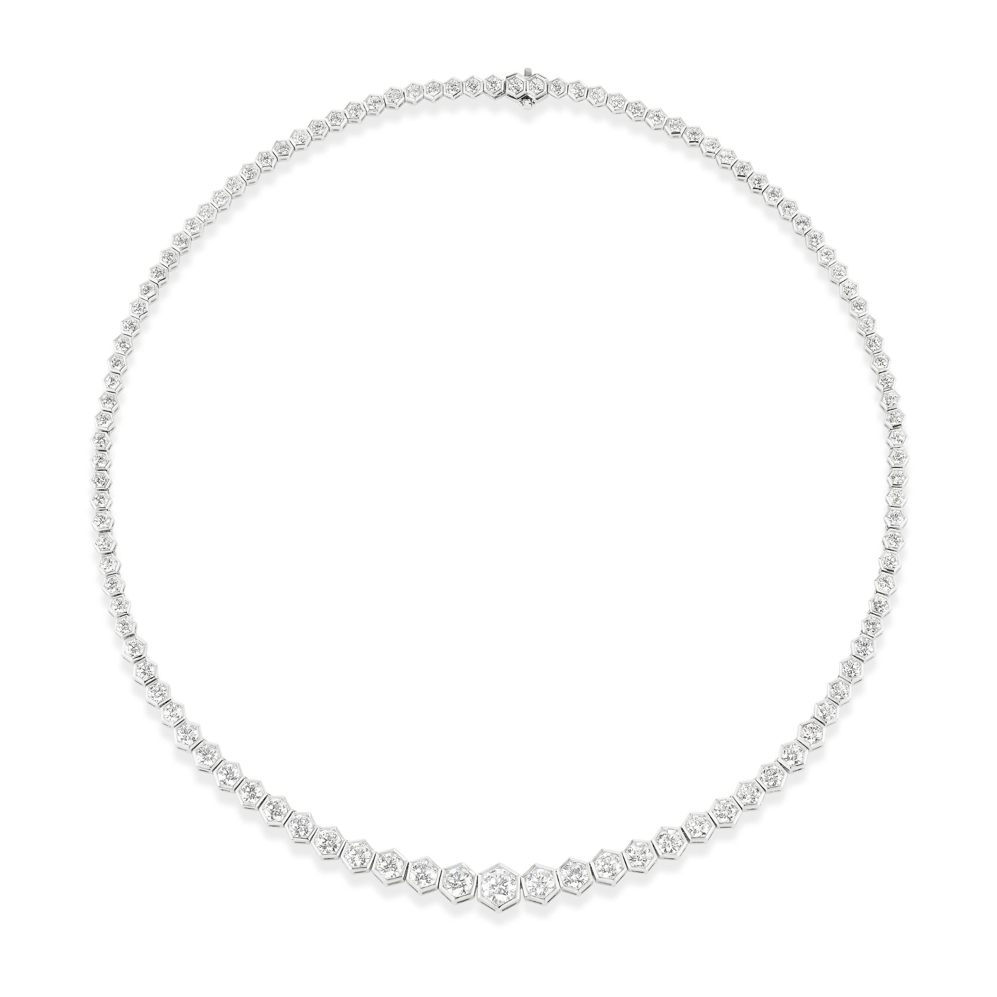 The Round Diamond Tennis Necklace in White Gold is a delicate 16-inch necklace with a continuous row of round diamonds that gradually decrease in size from the sparkling center to the clasp.