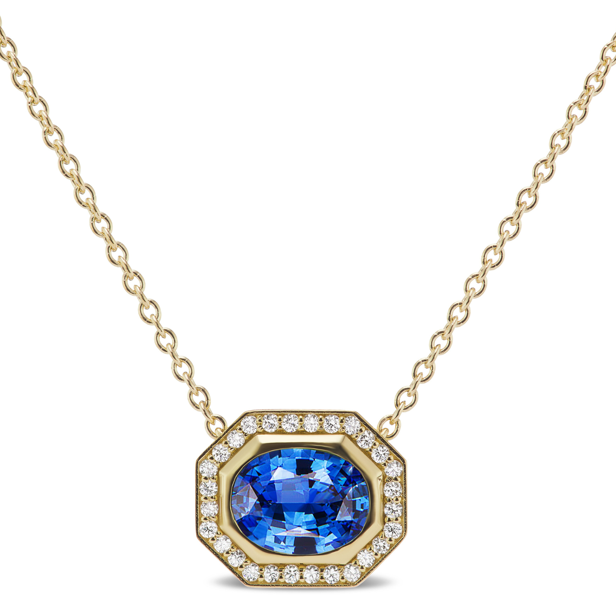 The East-West Set Pavé Halo Pendant features an oval blue sapphire framed by a diamond pavé halo, all set on a delicate 18K yellow gold chain.