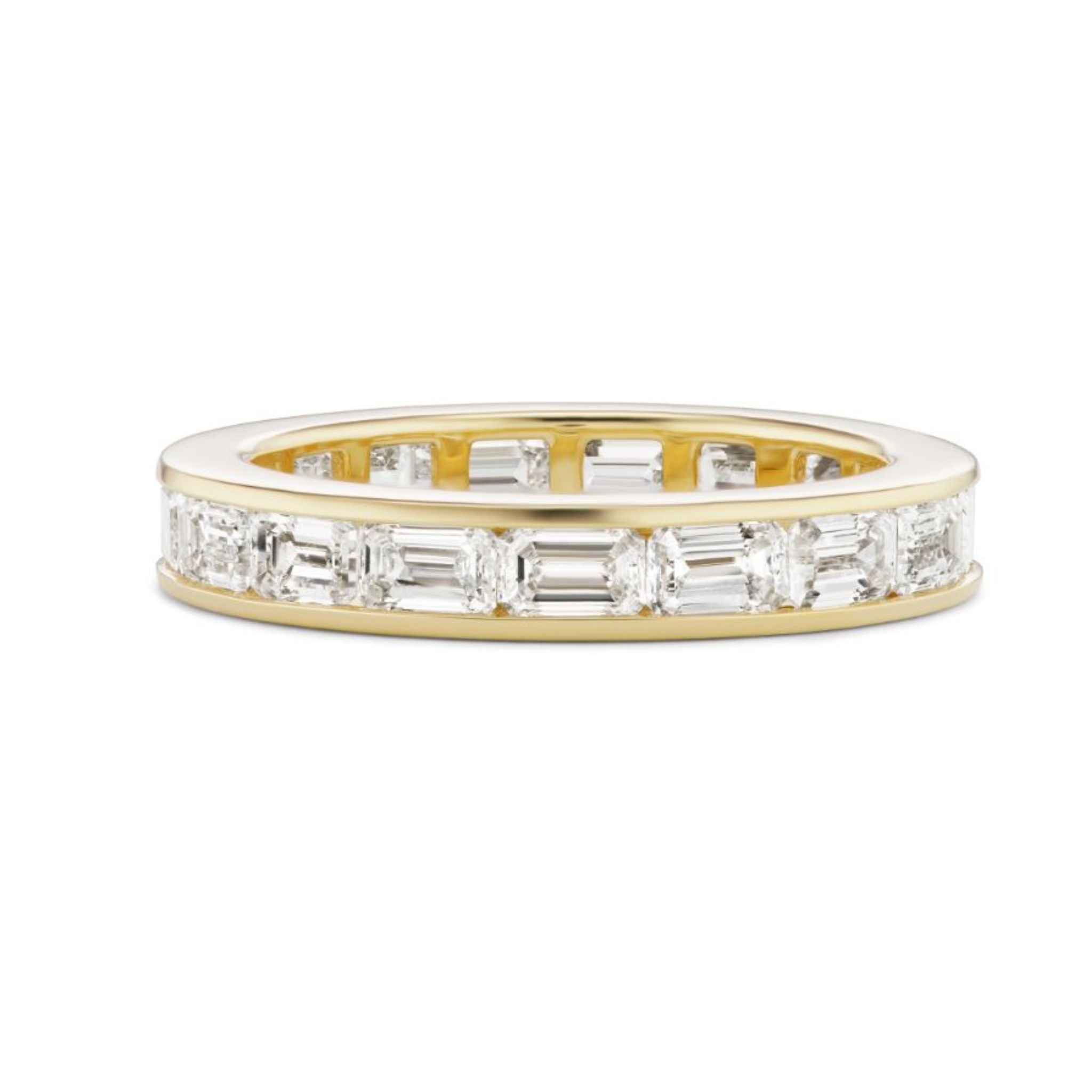 The Emerald Cut Diamond Channel Set Eternity Band features horizontally set rectangular and oval diamonds encircling the band—ideal as a celebration ring or a stunning custom engagement ring.