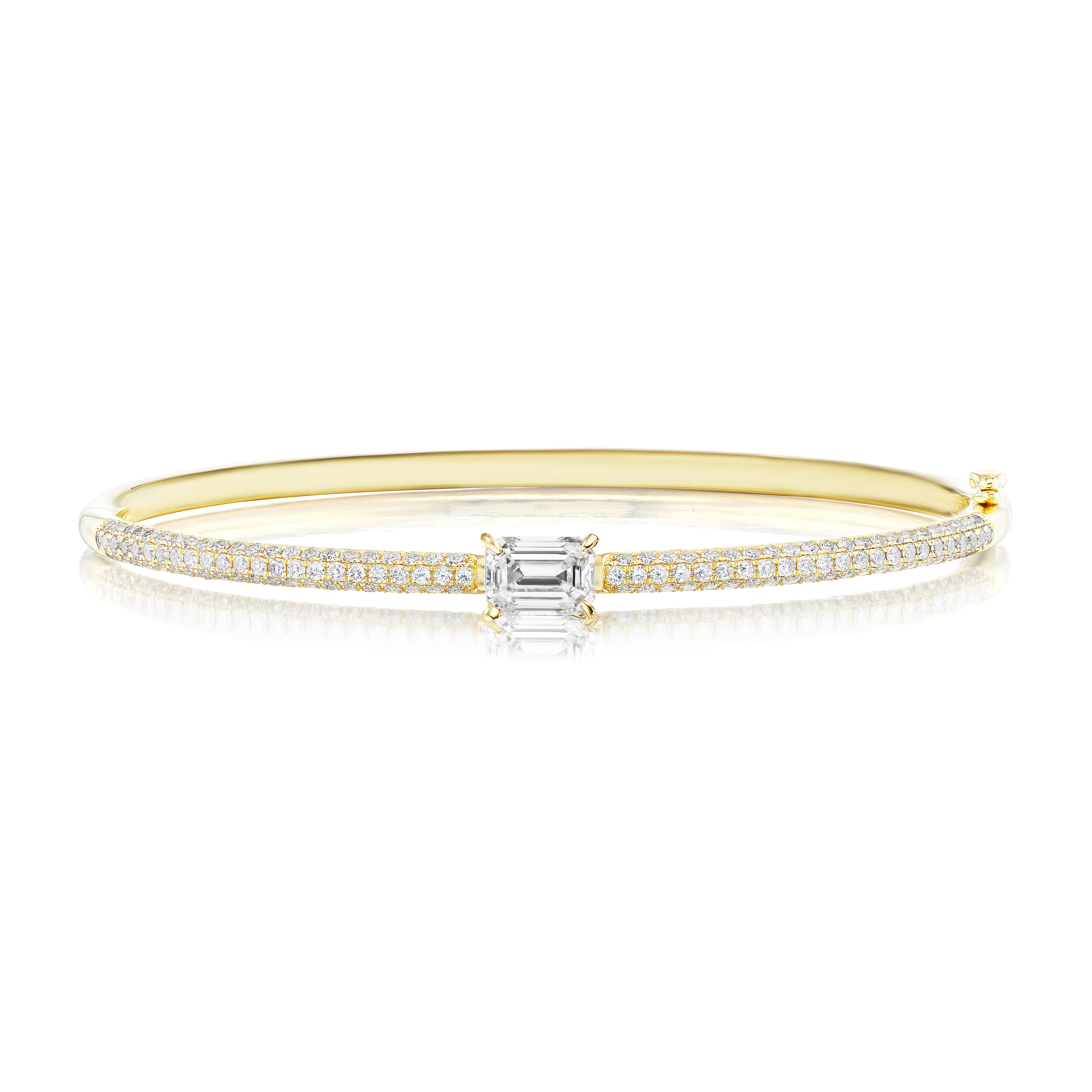 The East-West Set Emerald Cut Diamond Pavé Bangle in 18k gold showcases a central emerald-cut diamond, flanked by two pavé rows of round diamonds. This elegant, symmetrical piece features a smooth, polished finish.