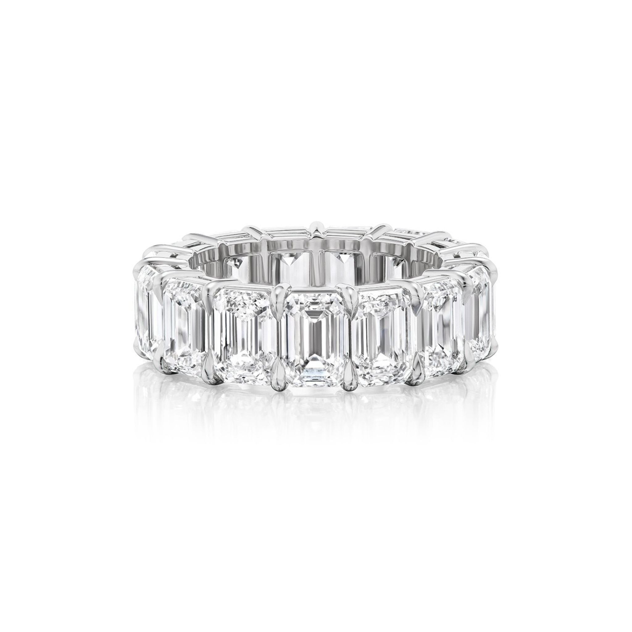 The Emerald Cut Diamond Eternity Band is a platinum ring with large emerald-cut diamonds set closely in a continuous loop, ideal as a unique engagement ring and shown on a white background.