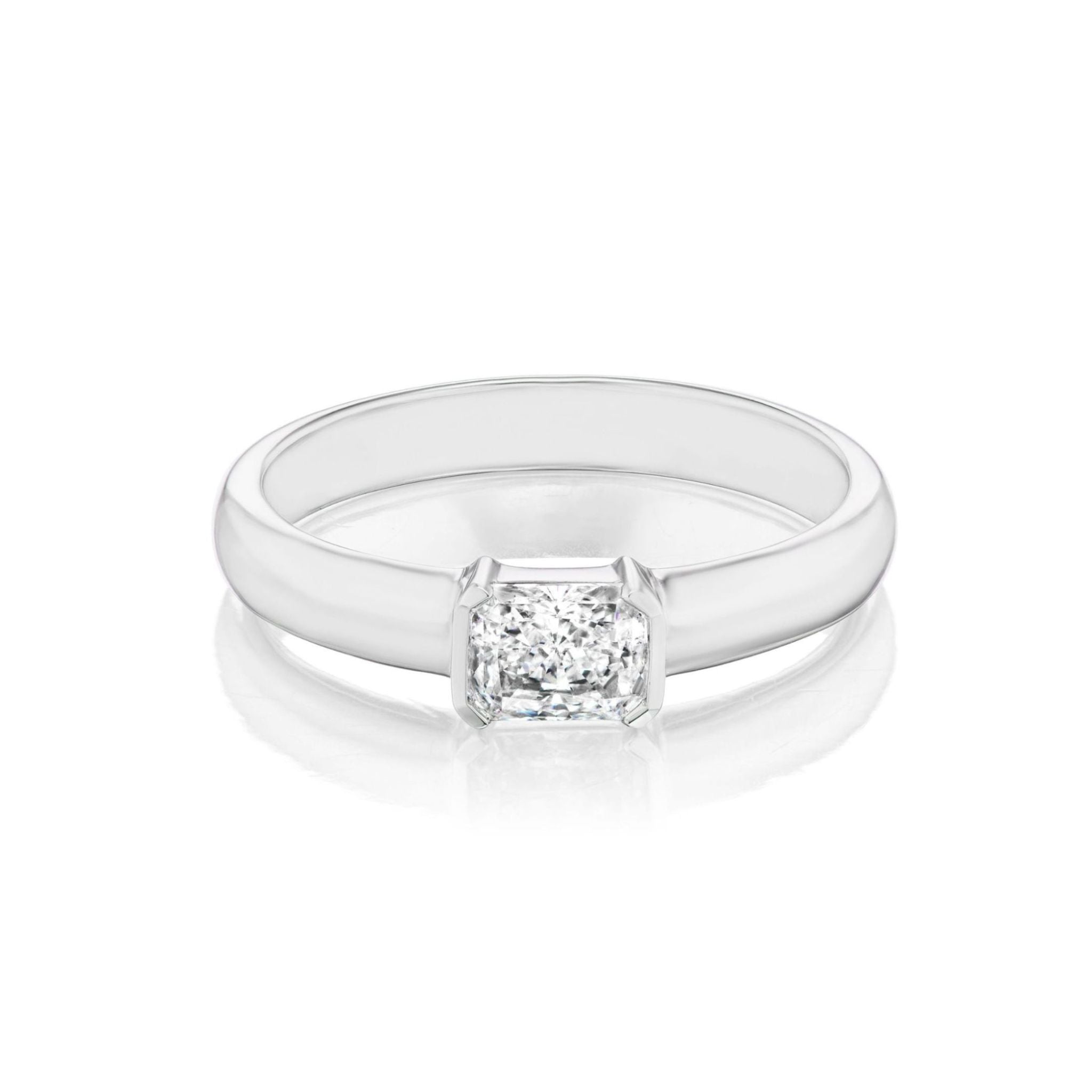 The East-West Radiant Cut Diamond Solitaire Band features a single radiant cut diamond set on a minimalist, sleek 18k white gold band in size 6.
