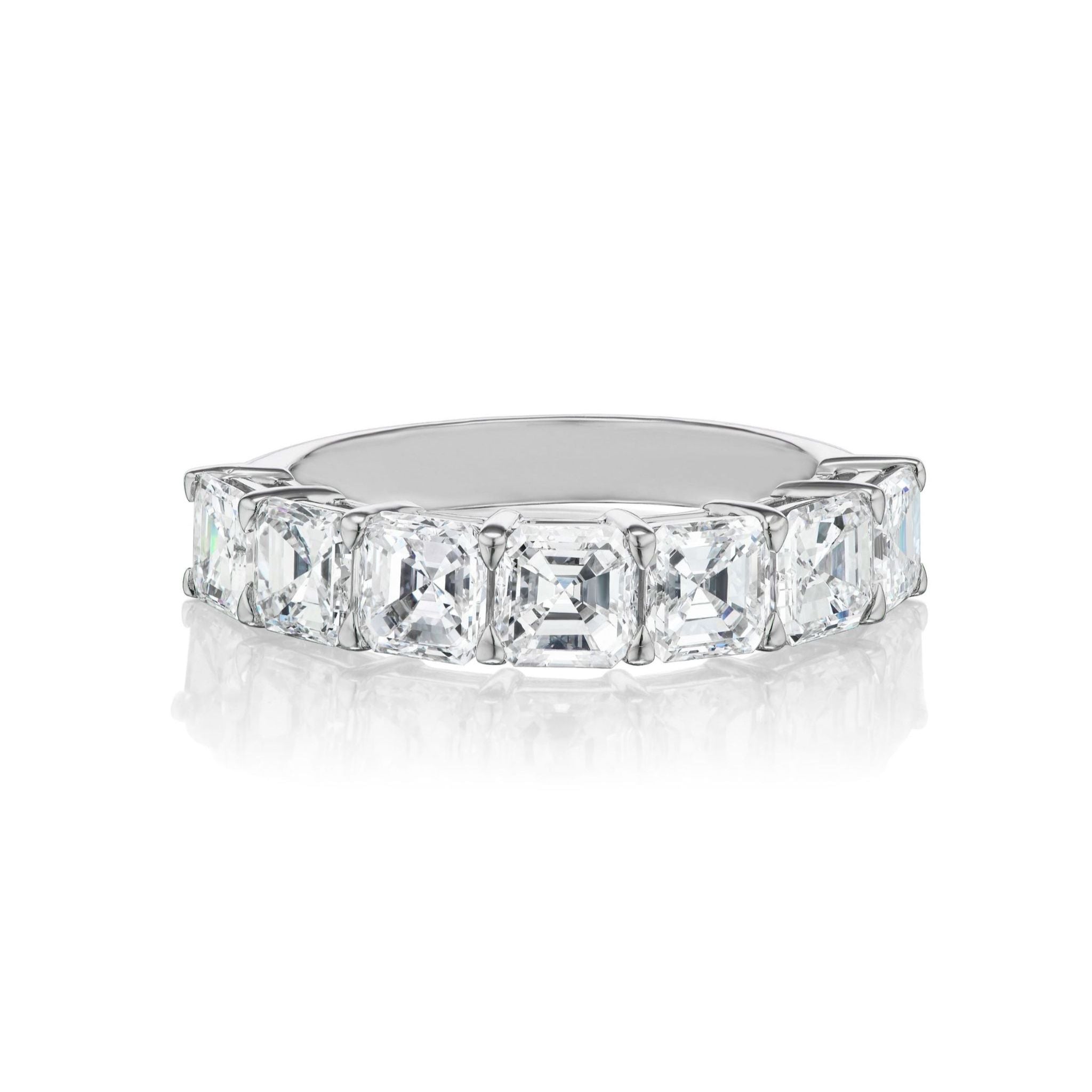The Asscher Cut Diamond Half Eternity Band features a platinum band set with seven large, rectangular step-cut Asscher cut diamonds in a row, displayed on a white background. This elegant design is perfect for bridal or celebration rings, blending timeless sophistication with radiant sparkle.