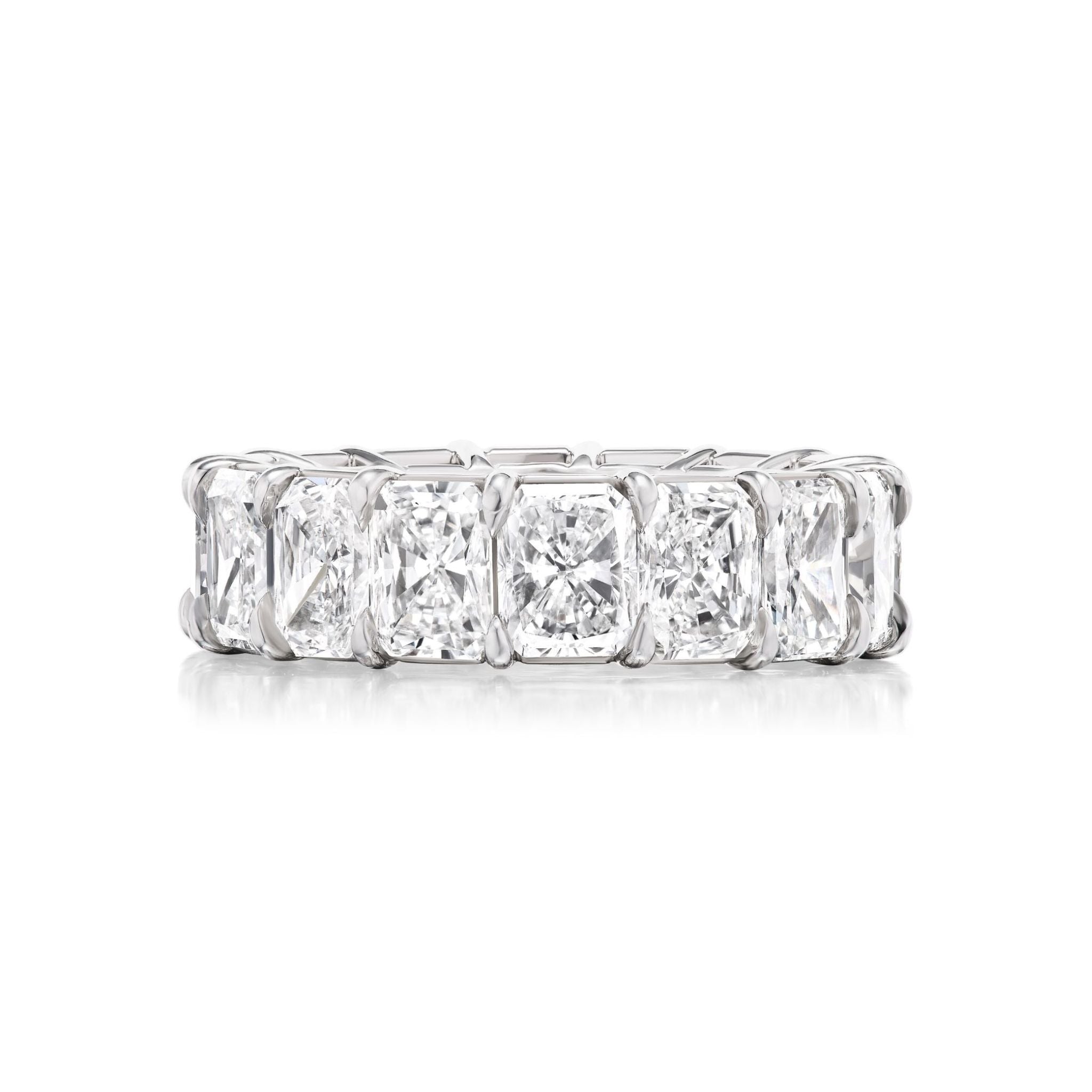 Introducing the Radiant Cut Diamond Eternity Band—a platinum band adorned with a continuous row of rectangular radiant cut diamonds, each securely held by four prongs. This timeless piece is a sophisticated choice for a bridal band or celebration ring.