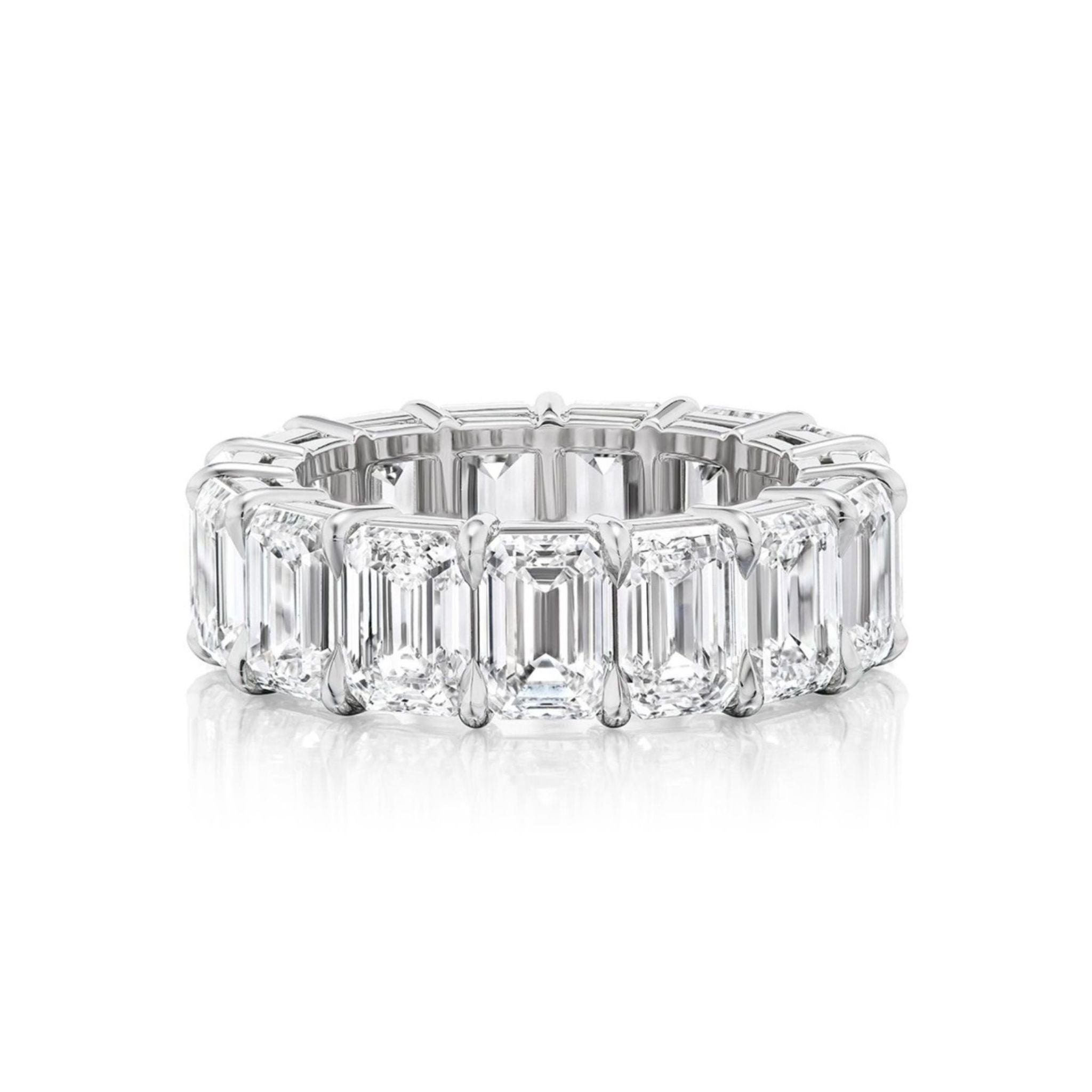 Showcased on a white background, the Emerald Cut Diamond Eternity Band features large rectangular emerald cut diamonds set all around its platinum band, making it an exquisite celebration ring.