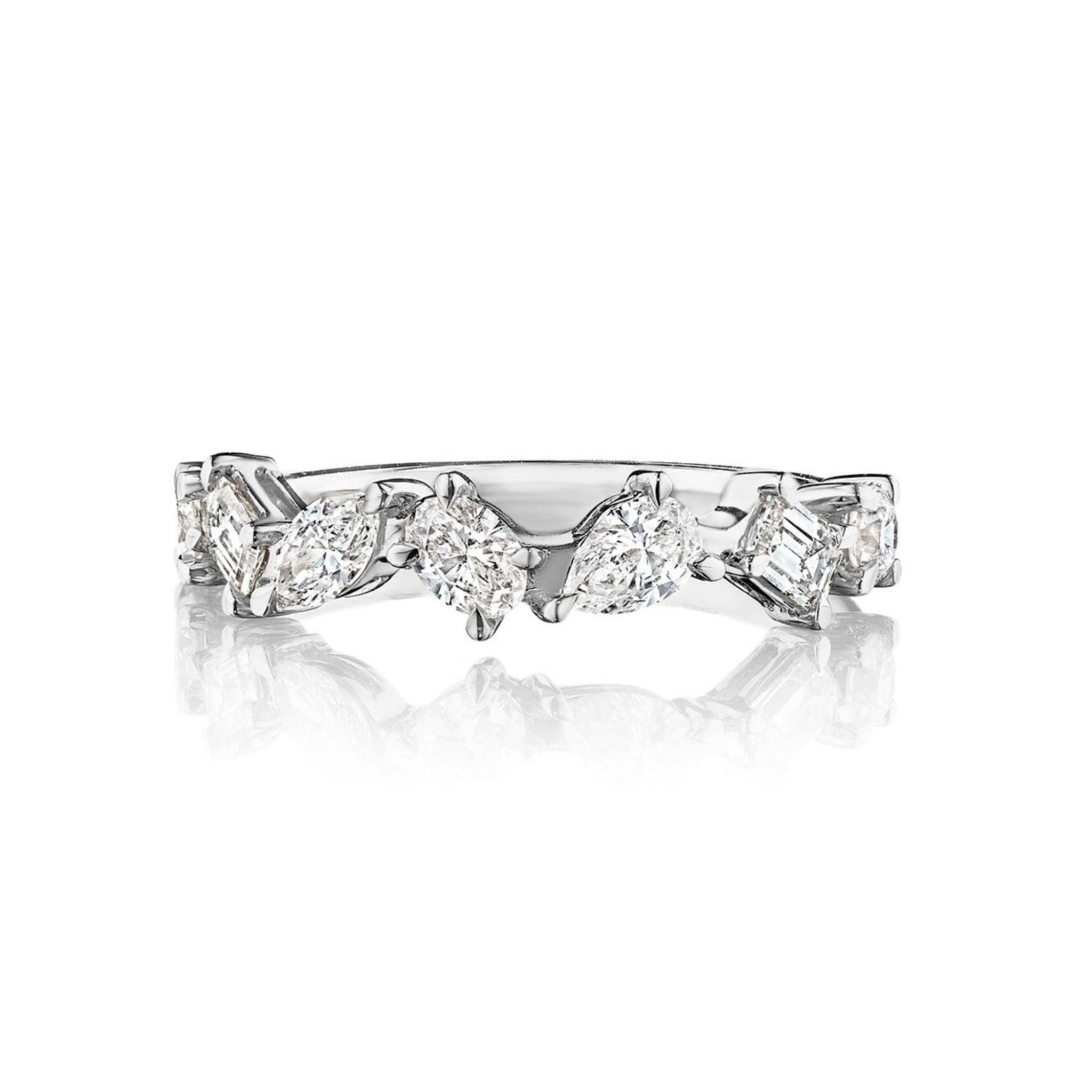 The Mixed Shape Diamond Half Eternity Band features a series of marquise, pear, and radiant cut diamonds set in sparkling silver, arranged in an elegant and delicate band. Pictured against a white background with a clear reflection beneath it, this exquisite piece perfectly captures the refined sophistication of bridal rings.
