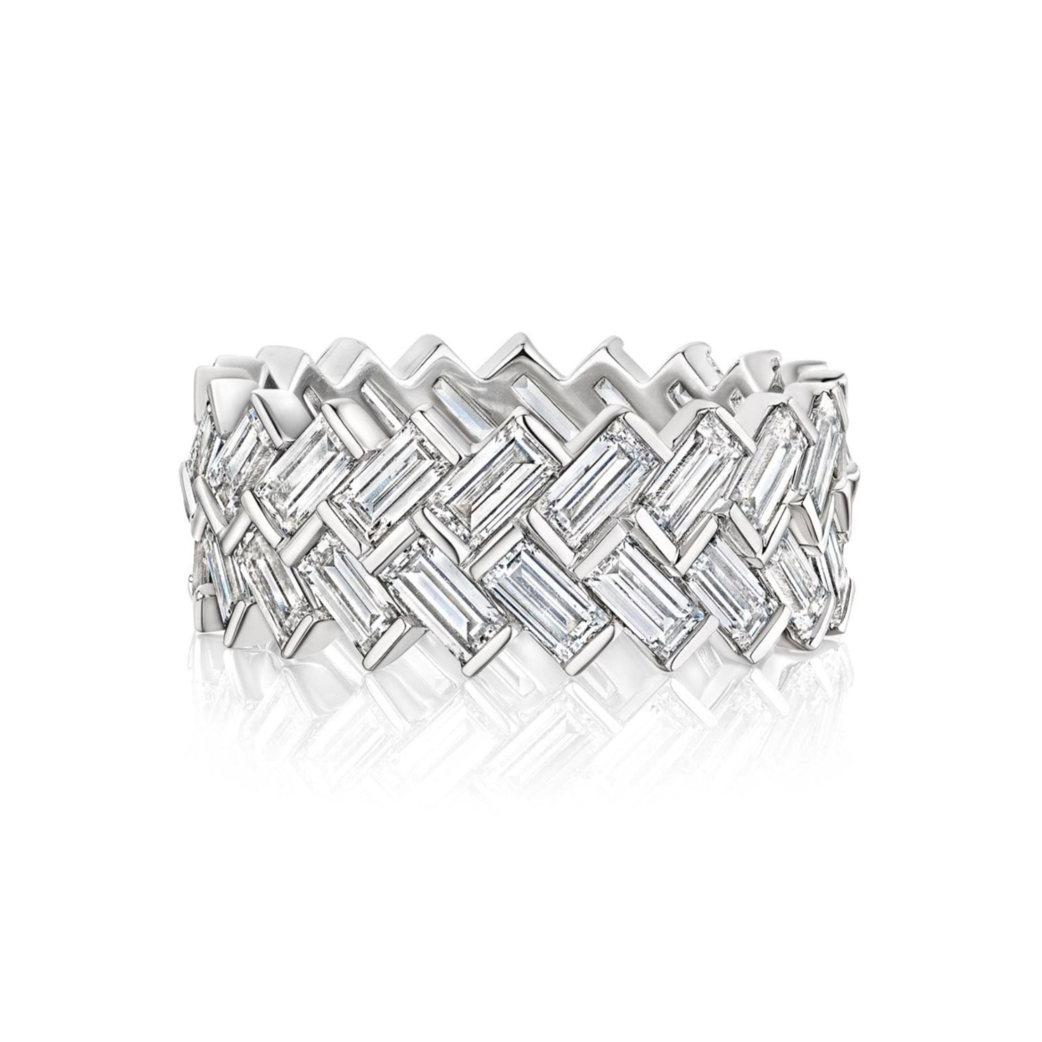 The Half-Bezel Set Chevron Diamond Eternity Band in white gold showcases a sophisticated woven design, featuring multiple rectangular baguette diamonds artfully arranged in an elegant chevron pattern, displayed against a pristine white background.