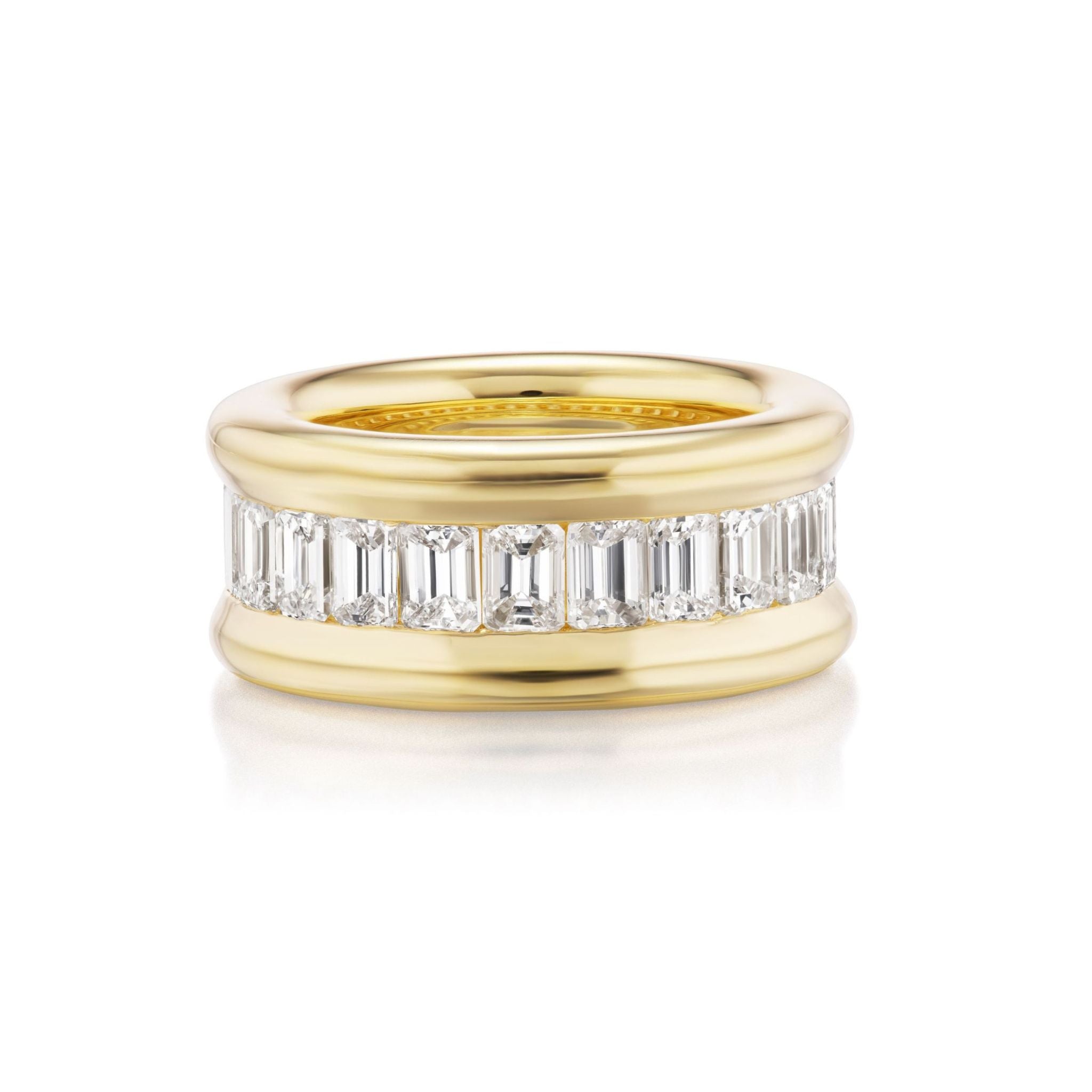 The Channel Set Emerald Cut Diamond Eternity Band is crafted in luxurious 18K yellow gold and features a continuous row of rectangular, emerald-cut diamonds set in the center, bordered by smooth gold edges and displayed against a white background.