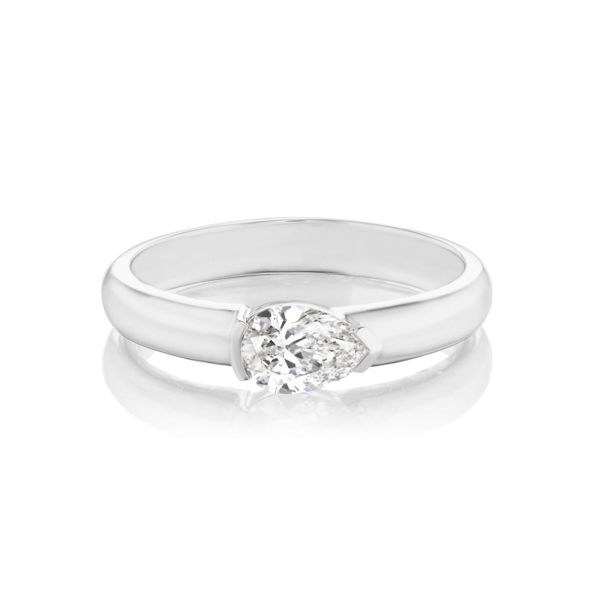 Introducing the East-West Pear Diamond Solitaire Band: a silver ring showcasing a pear-shaped diamond solitaire set horizontally in a sleek, polished band, displayed against a white background. This customizable piece effortlessly blends elegance and sophistication, making it perfect for any occasion.