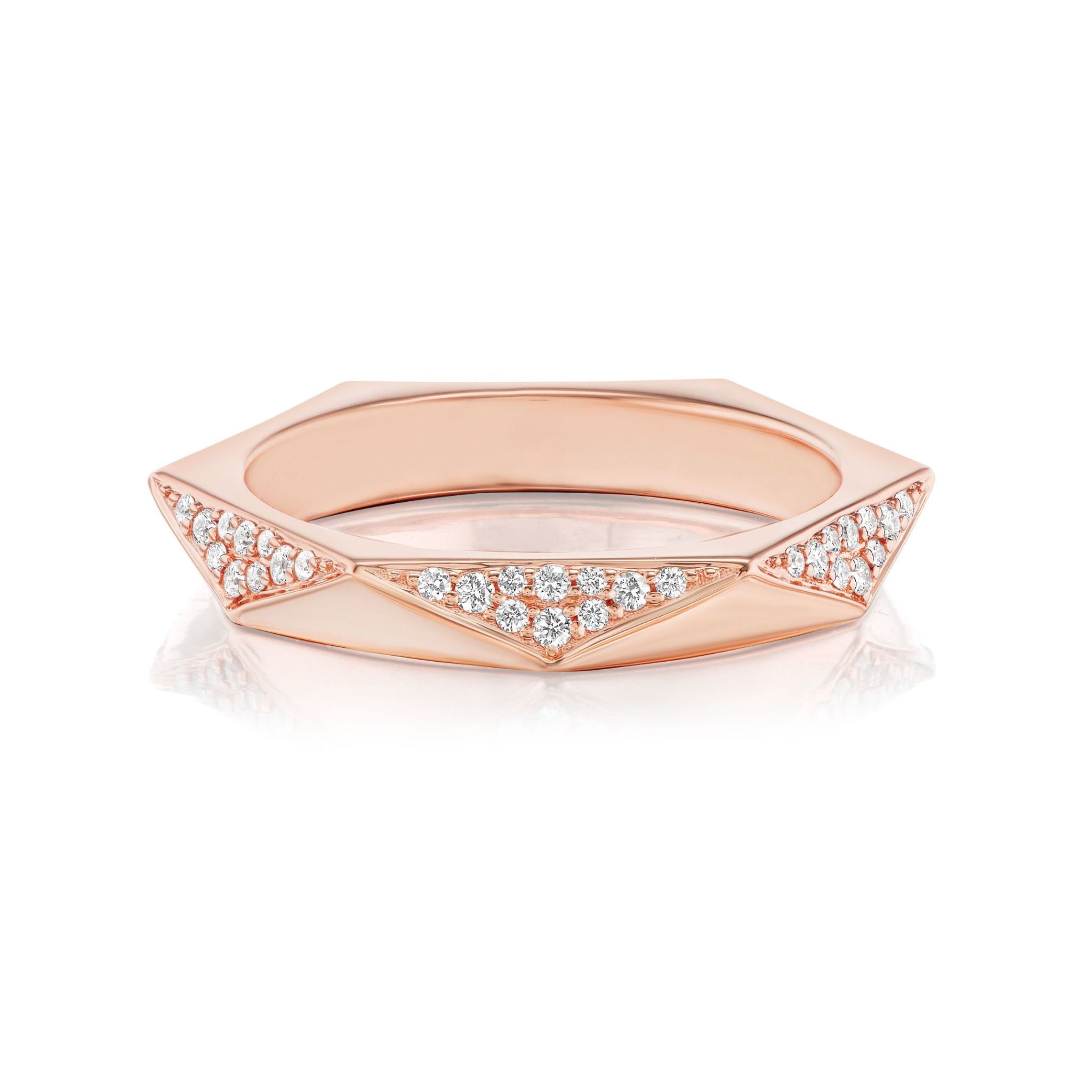 The Triangular Geometric Pavé Band is crafted in 18k rose gold and showcases a faceted design with clusters of small, round SI clarity diamonds set within triangular sections encircling the band.