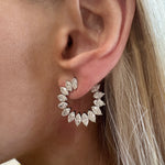 Close-up of a person's ear wearing the Climbing Ivy Front-to-Back Hoops in White Gold with marquise diamonds (SI1-SI2 clarity), with straight blonde hair partially visible.