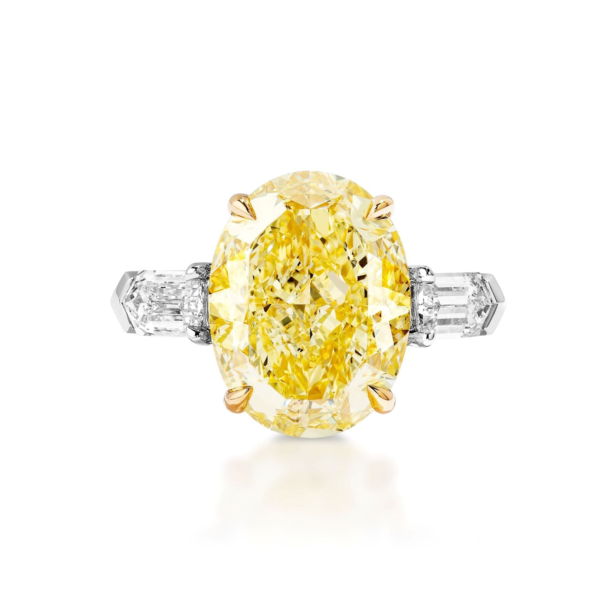 The Fancy Yellow Oval Diamond Engagement Ring with Bullet Side Stones features an oval yellow diamond set in gold prongs, accented by two tapered white baguette diamonds on each side of the band.