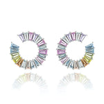 A pair of Confetti Wheel of Fortune Earrings in white gold, featuring emerald-cut diamonds and multicolor sapphires arranged in a spiral, displayed on a white reflective background.