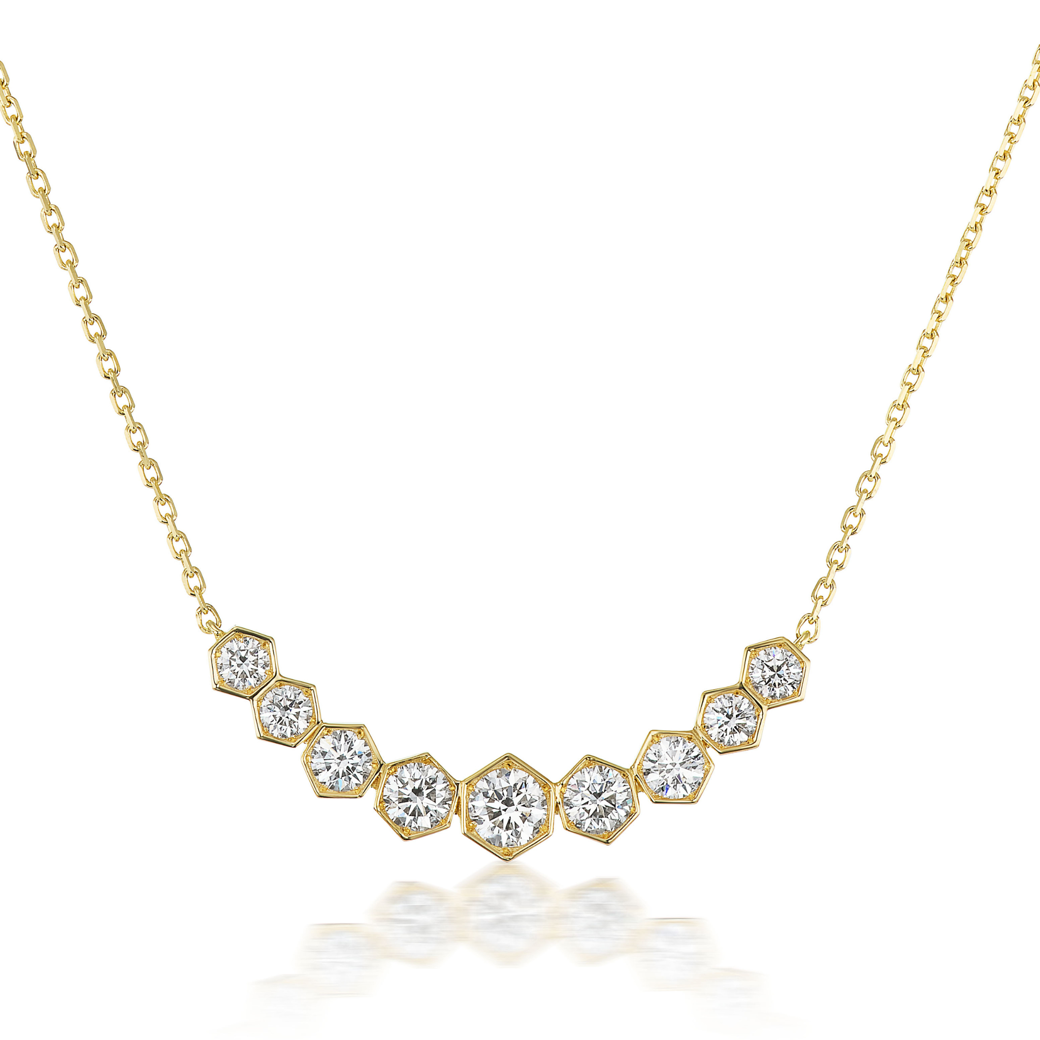 The Graduated Hexagon Necklace with Round Brilliant Diamonds features nine hexagonal settings on a delicate 18K gold chain, each holding a round diamond and arranged in an elegant, curved design.