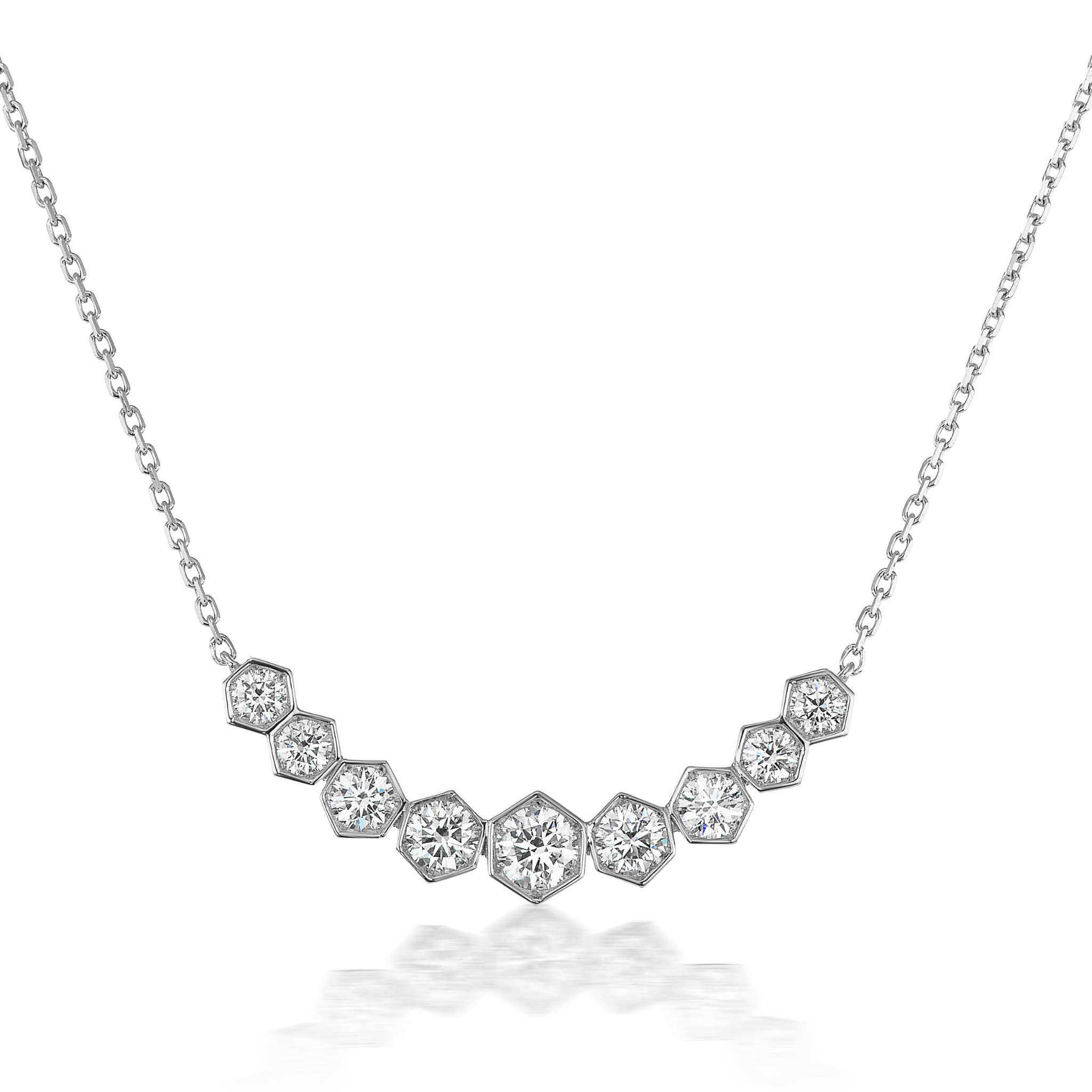 The Graduated Hexagon Necklace with Round Brilliant Diamonds features nine hexagon-shaped settings on a delicate silver chain, each holding a round diamond arranged in a gentle curve for an elegant, sparkling pendant look.
