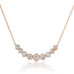 The Bezel Set Hexagon Necklace with Graduated Brilliant Diamonds features eight rose gold 18k hexagon settings, each holding a round diamond, arranged in a gentle curve on a delicate chain.