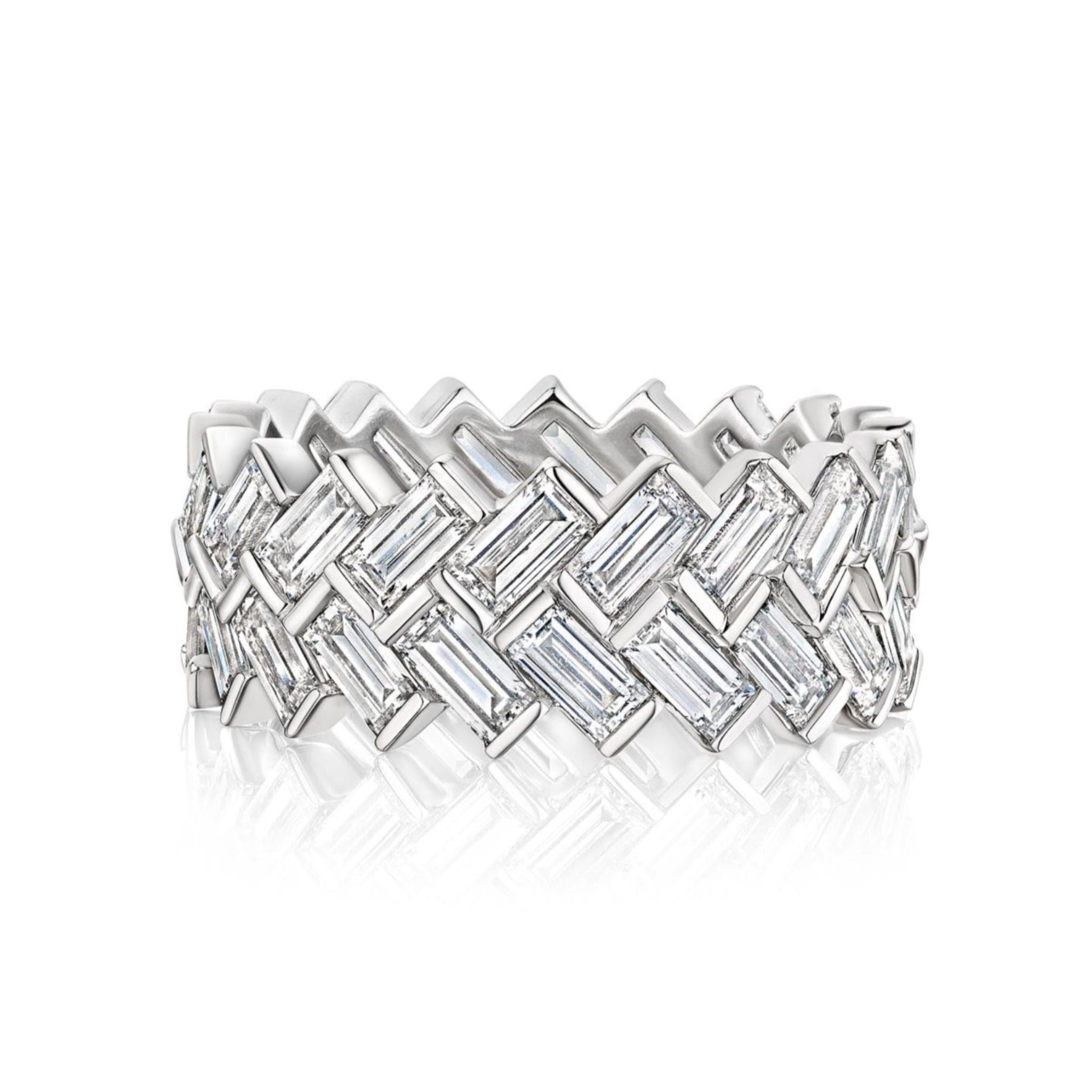 The Half-Bezel Set Chevron Diamond Eternity Band in White Gold features an interwoven zigzag chevron design with rectangular baguette diamonds, beautifully reflecting light on a white background.