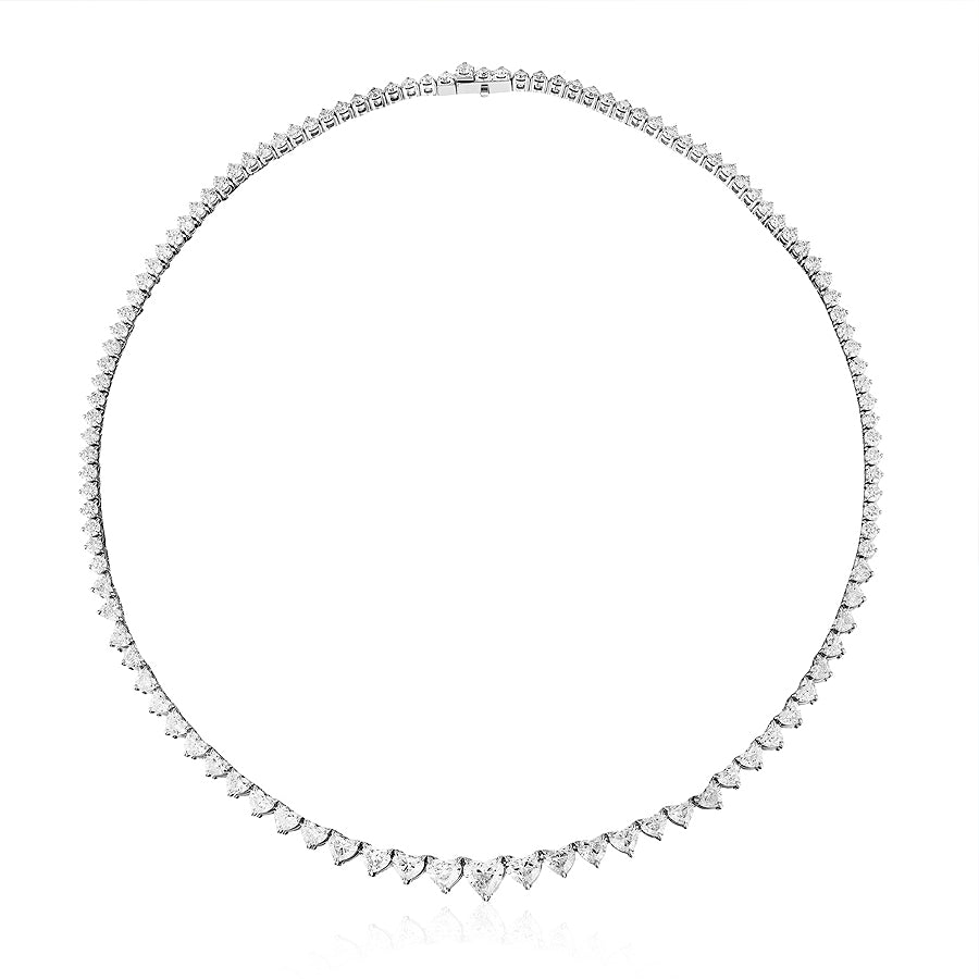 The Graduated Heart Diamond Tennis Necklace in White Gold features a symmetrical row of sparkling heart-shaped diamonds set in 18K white gold, displayed on a plain white background.