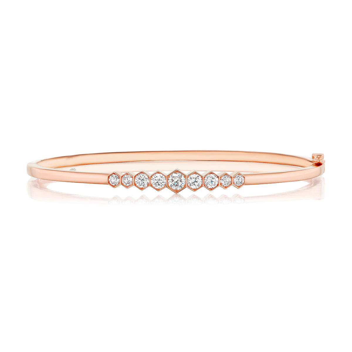 The Graduated Hexagon Bezel Set Diamond Bangle features round white diamonds in graduated sizes, set in 18k rose gold with a sleek, polished finish and minimalist, elegant style.