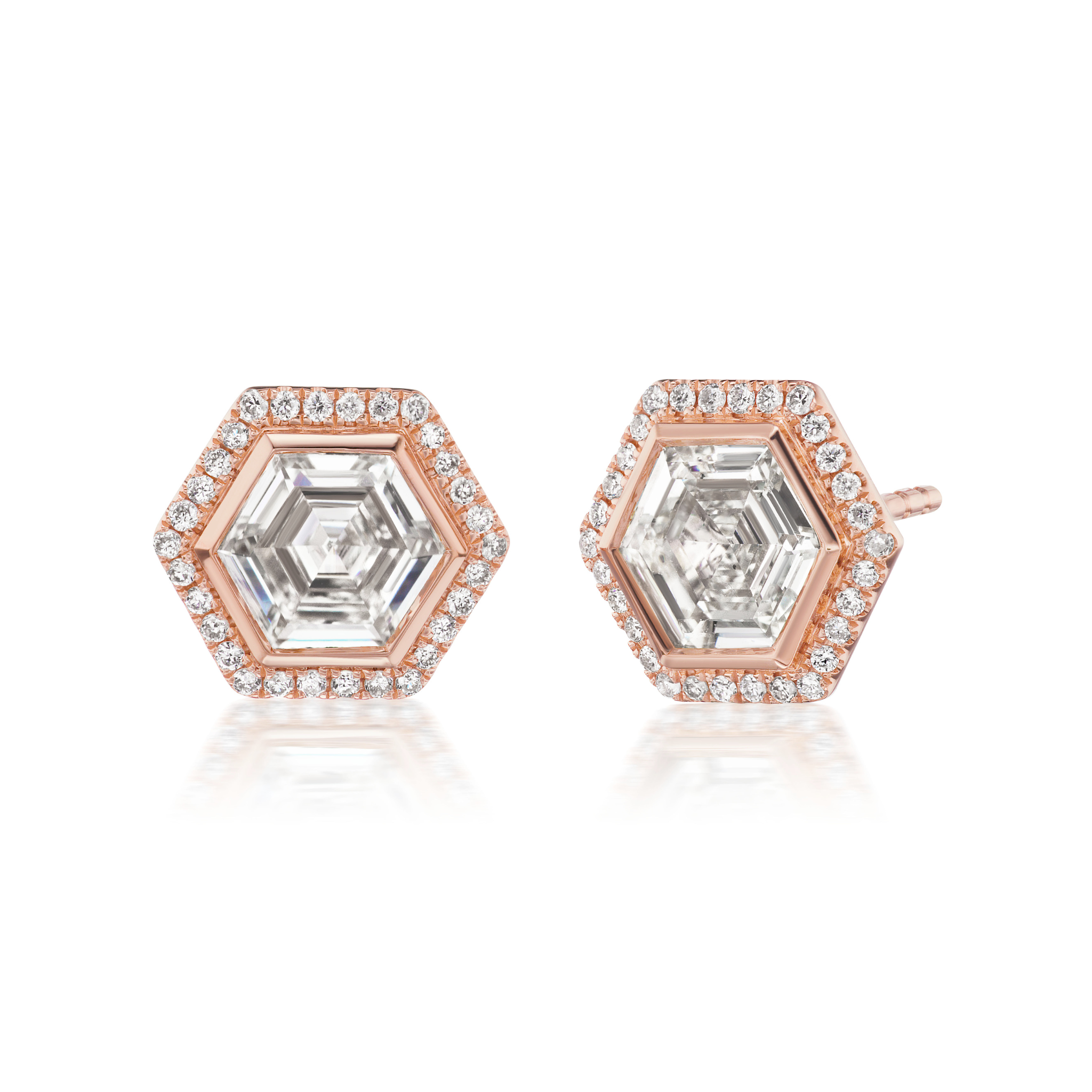 The Hexagon and Round Cut Diamond Studs in Rose Gold showcase a central step-cut diamond encircled by round brilliant cut diamonds, all beautifully set in 18k rose gold.