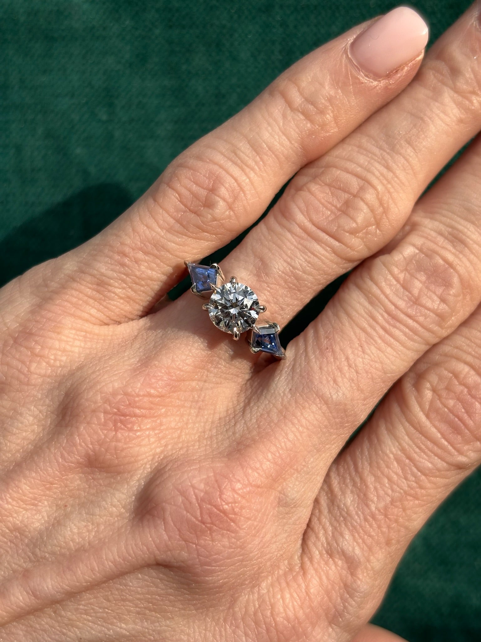 Bespoke Round Diamond Engagement Ring in White Gold with Kite Shape Blue Sapphire Side Stones