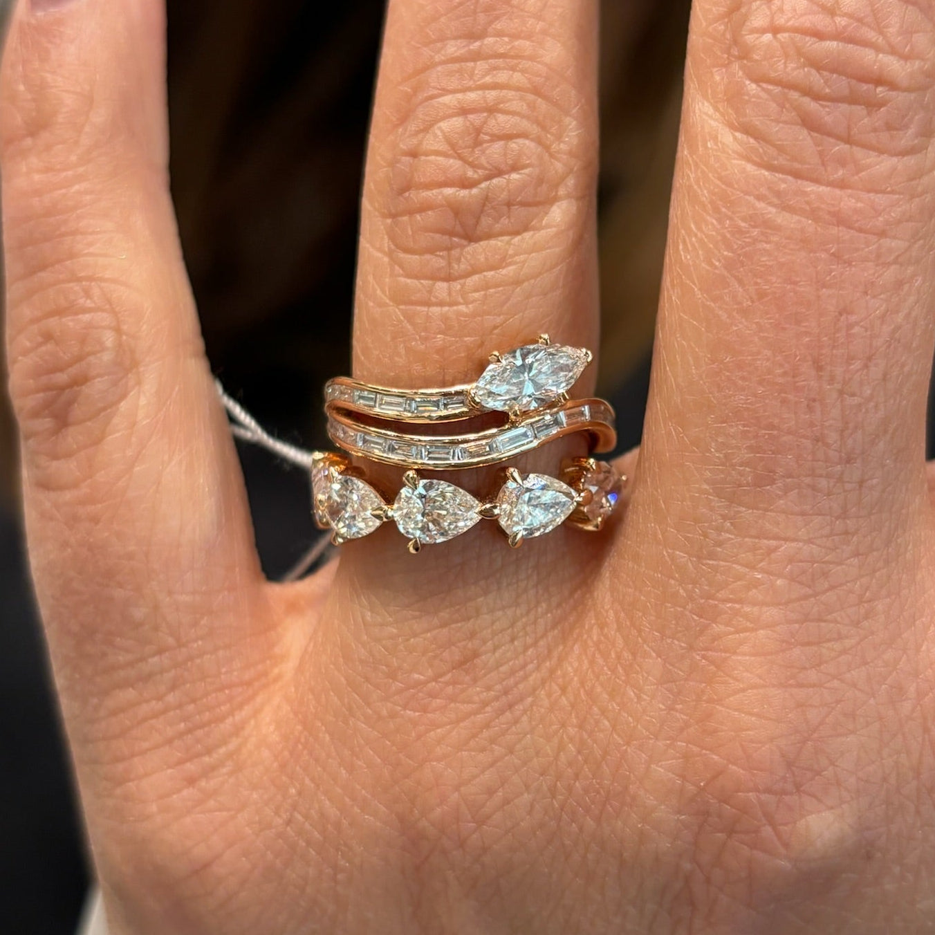 A close-up of a hand wearing the Snake Wave Channel Set Baguette Diamond Ring with Marquise Diamond in yellow gold, showcasing elegant baguette and marquise diamond accents on the ring finger.