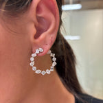 Close-up of a person’s ear wearing Mixed Shape Diamond Front to Back Hoops in White Gold, featuring sparkling clear gemstones. The blurred neutral background highlights the exquisite shine of these diamond hoops.