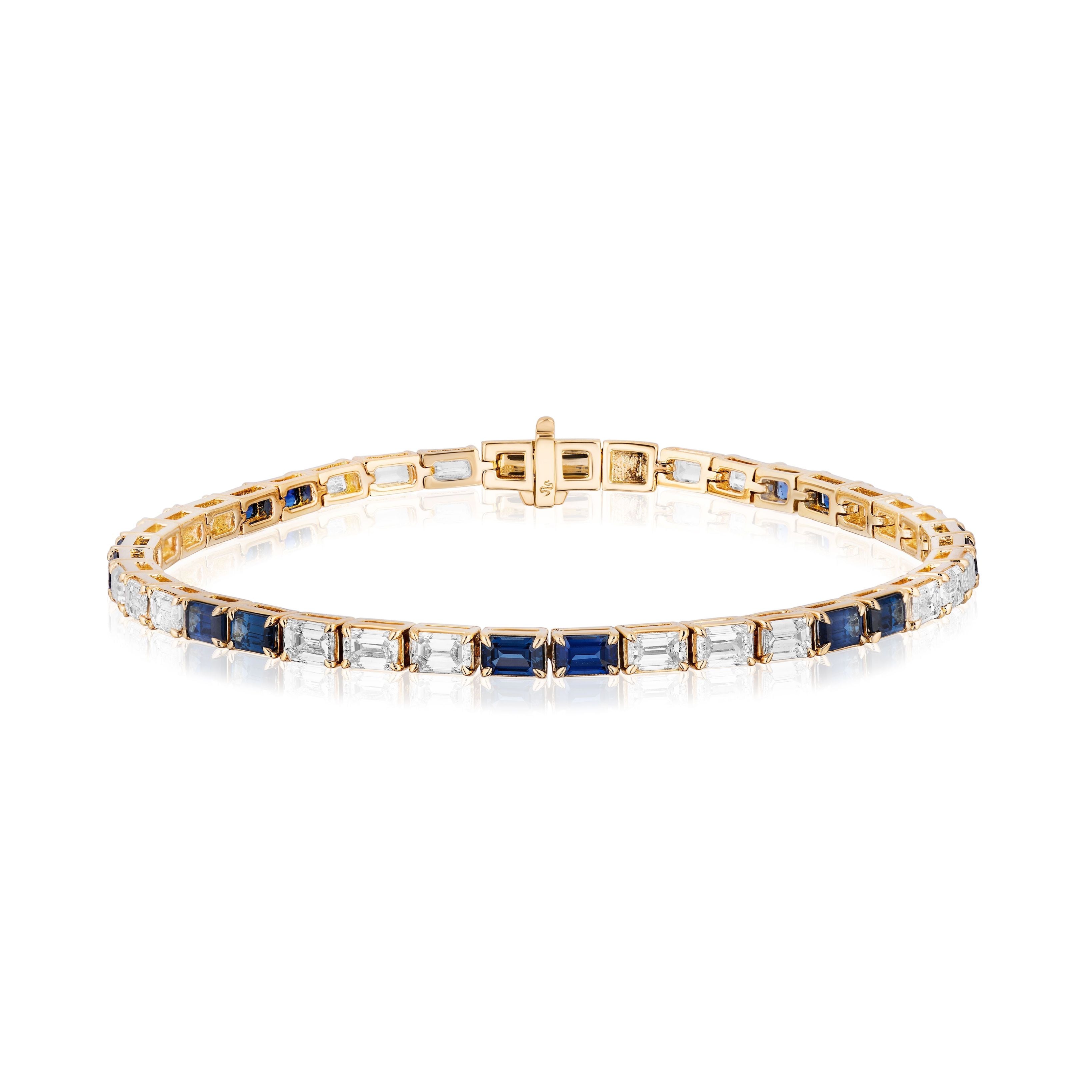 The East West Diamond and Sapphire Tennis Bracelet in Yellow Gold showcases alternating emerald cut blue sapphires and diamonds, set in 18K yellow gold, displayed on a white background.