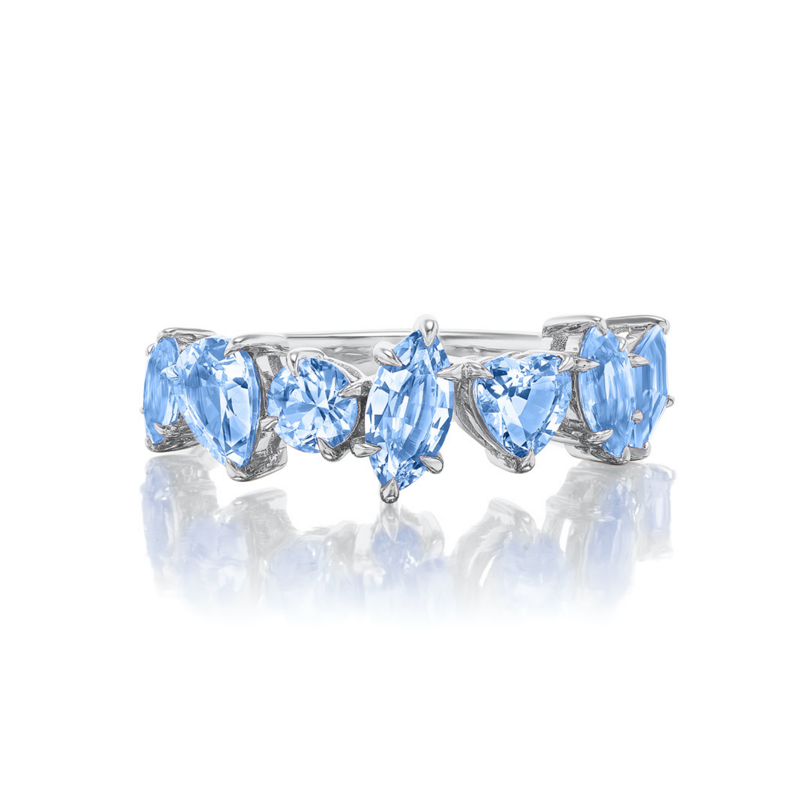 The Sapphire Mixed Shape Cluster Ring is a silver half eternity band showcasing five sapphires in oval, marquise, round, and heart shapes, arranged in a row on a white reflective surface.