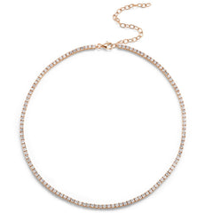 The Adjustable Round Brilliant Diamond Tennis Necklace features small, round brilliant diamonds set in a delicate 18K gold chain with an adjustable clasp and extension chain.