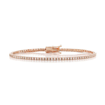 The Skinny Round Brilliant Diamond Tennis Bracelet features a row of sparkling diamonds set in delicate rose gold, secured with a clasp and beautifully displayed against a white background.
