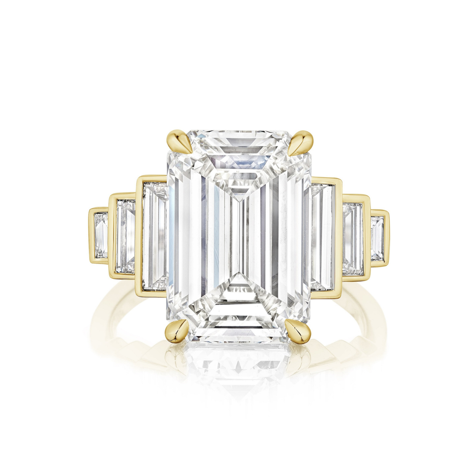 The Triple Echo Emerald Cut Diamond Engagement Ring showcases a bezel-set emerald cut center and three graduated baguette side stones on each side in a stepped design, crafted in 18k gold.