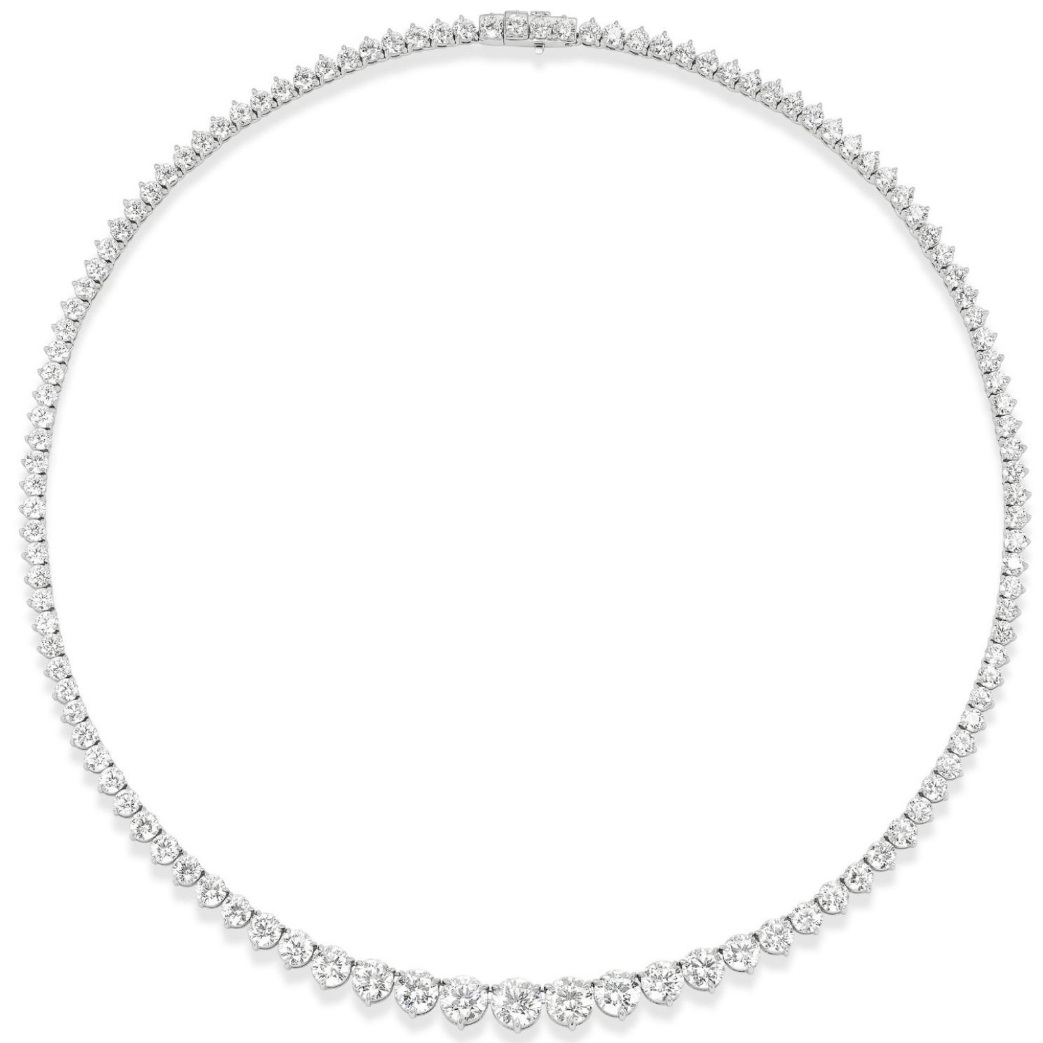 The Medium Graduated Round Diamond Tennis Necklace showcases a single row of round diamonds, set in white metal, with the largest stones at the center gradually tapering to smaller sizes toward the clasp.
