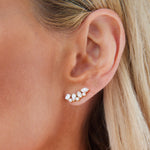 Close-up of a woman's ear with blonde hair, wearing Mixed Shape Diamond Ear Crawlers in 18k white gold featuring marquise and round diamonds for an elegant, modern look.