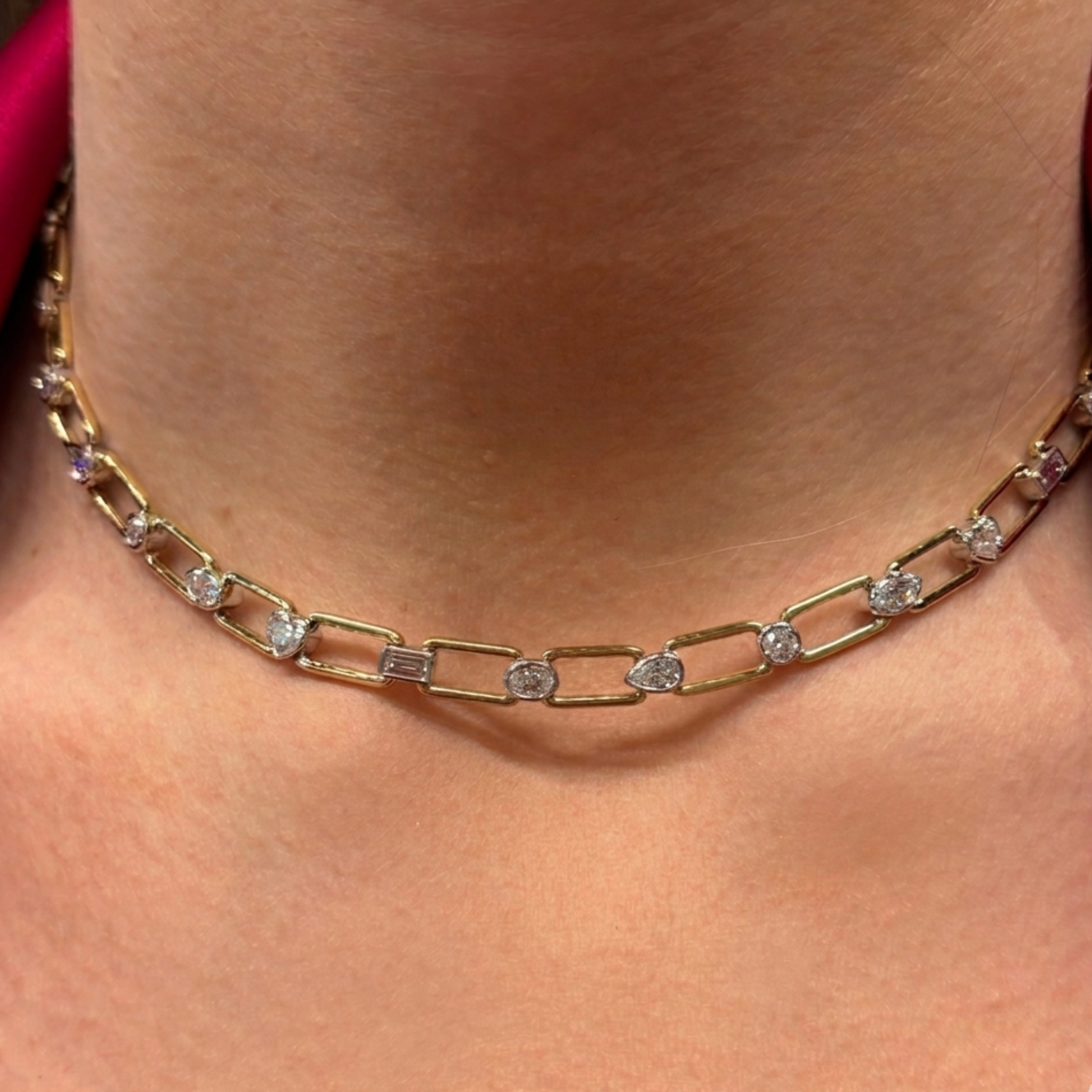 A close-up of a person's neck wearing the Mixed Shape Bezel Set Diamond Chain Link Necklace in yellow gold, featuring rectangular links with bezel set mixed shape diamonds.