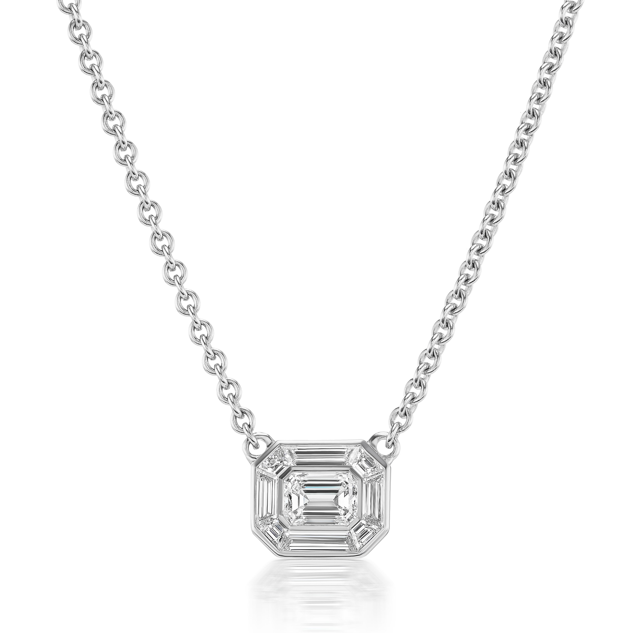 The Emerald Cut Mosaic Pendant in White Gold features a sparkling emerald-cut diamond set in an elegant 18K white gold frame, suspended from a fine silver chain for a dazzling effect.