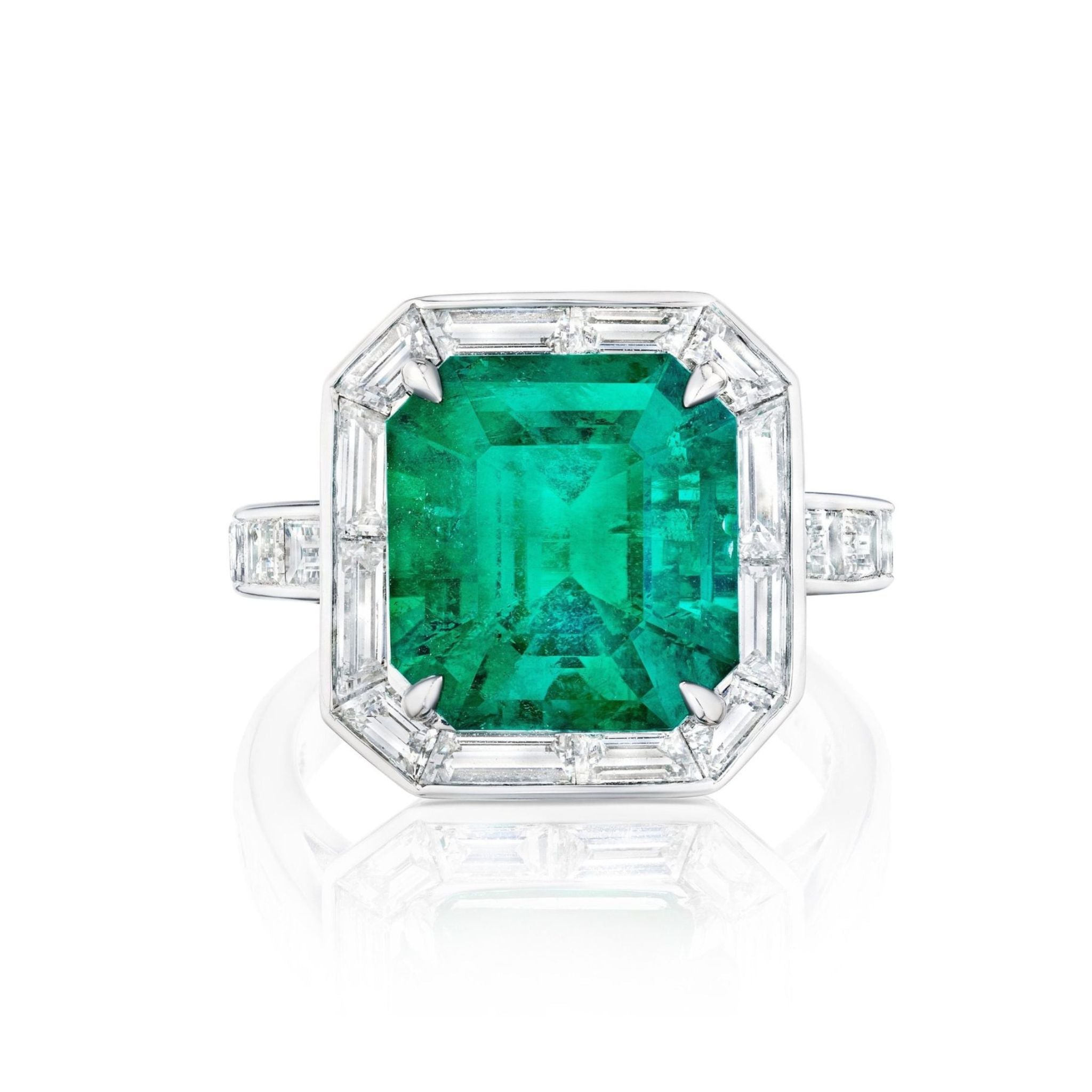 The Mosaic Asscher Cut Emerald and Baguette Diamond Cocktail Ring in Platinum features a striking emerald center, accented by baguette and small diamonds on the band, showcased against a white background.