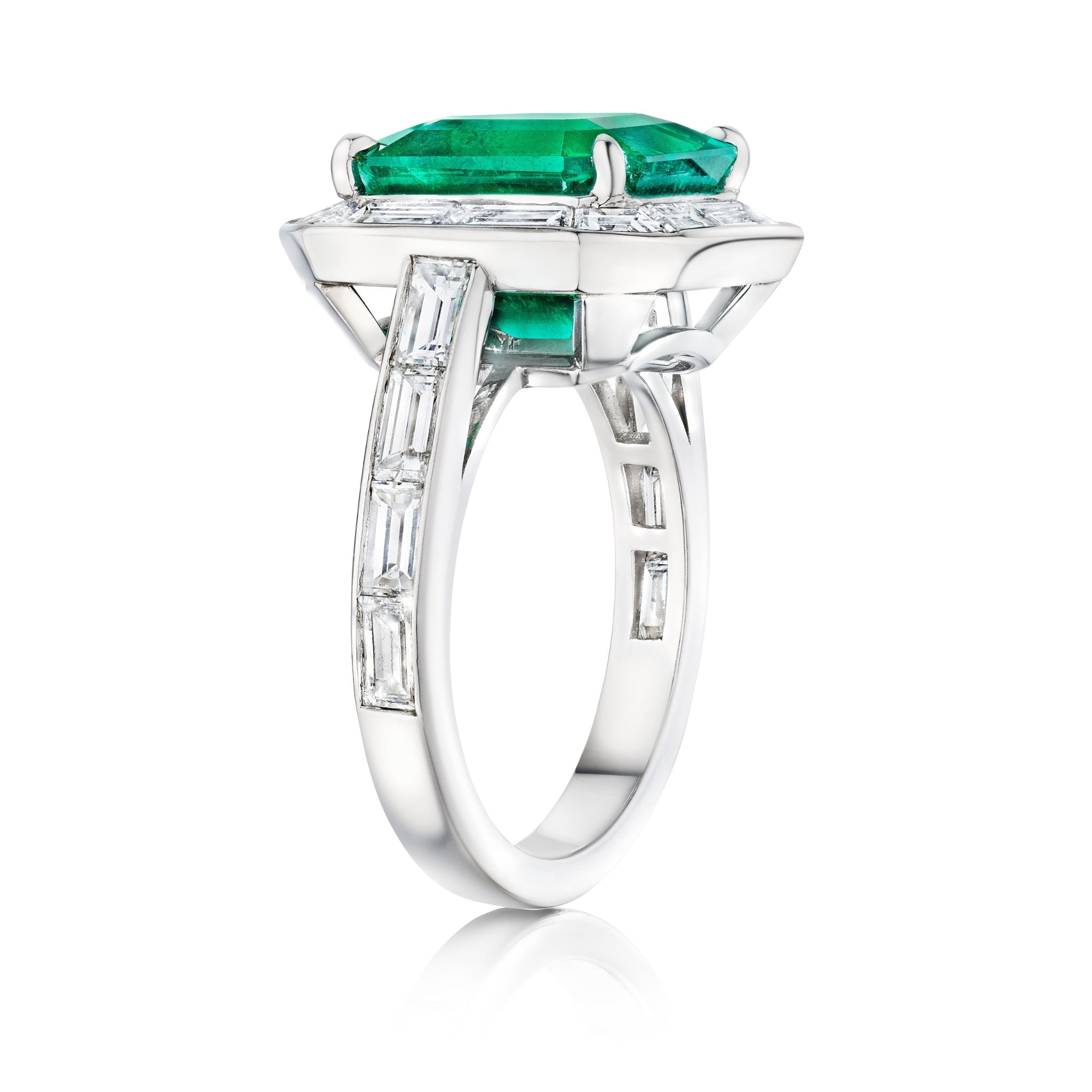 The Mosaic Asscher Cut Emerald and Baguette Diamond Cocktail Ring in Platinum features a striking asscher cut emerald, accented by baguette diamonds along the band and center, shown from a side angle on a white background.