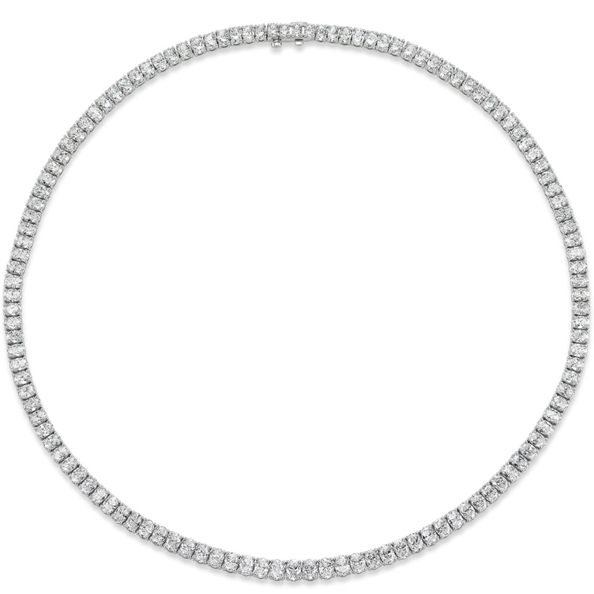 The Oval Diamond Tennis Necklace in White Gold is displayed in a perfect circle on a white background, showcasing sparkling oval-shaped diamonds set closely together in a continuous, elegant line crafted from 18K white gold.